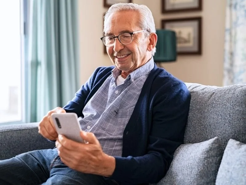 an older man with alzheimers checking his phone for his medicaid payment