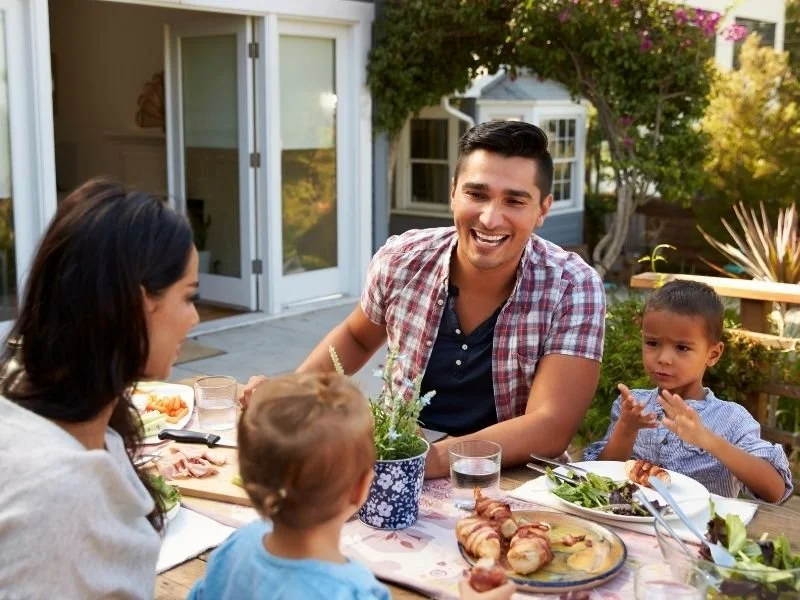 A family with long term care insurance eating lunch in their back yard