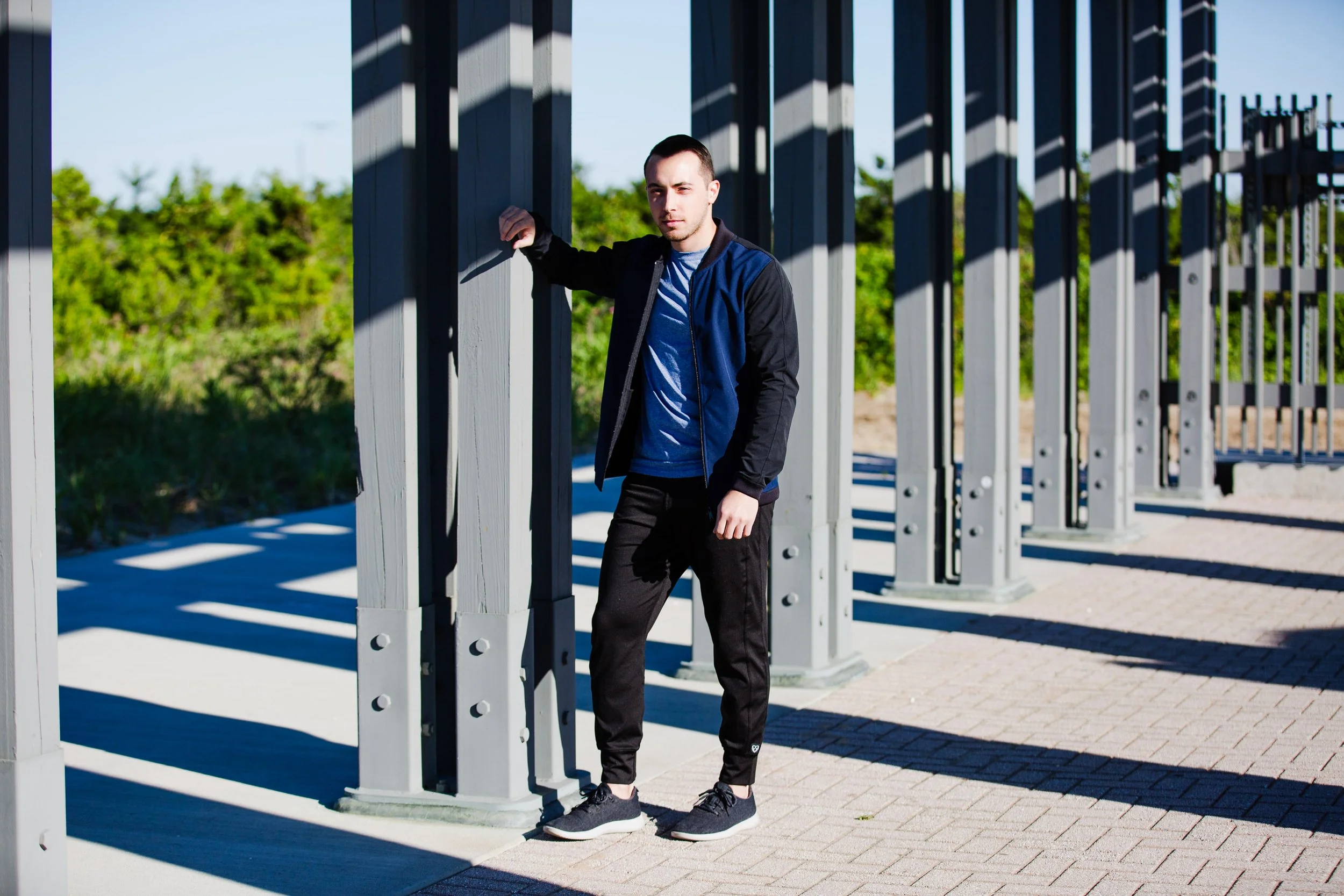 Man walking along Sandy Hook boardwalk near the beach, captured during a laid-back NJ brand photography session