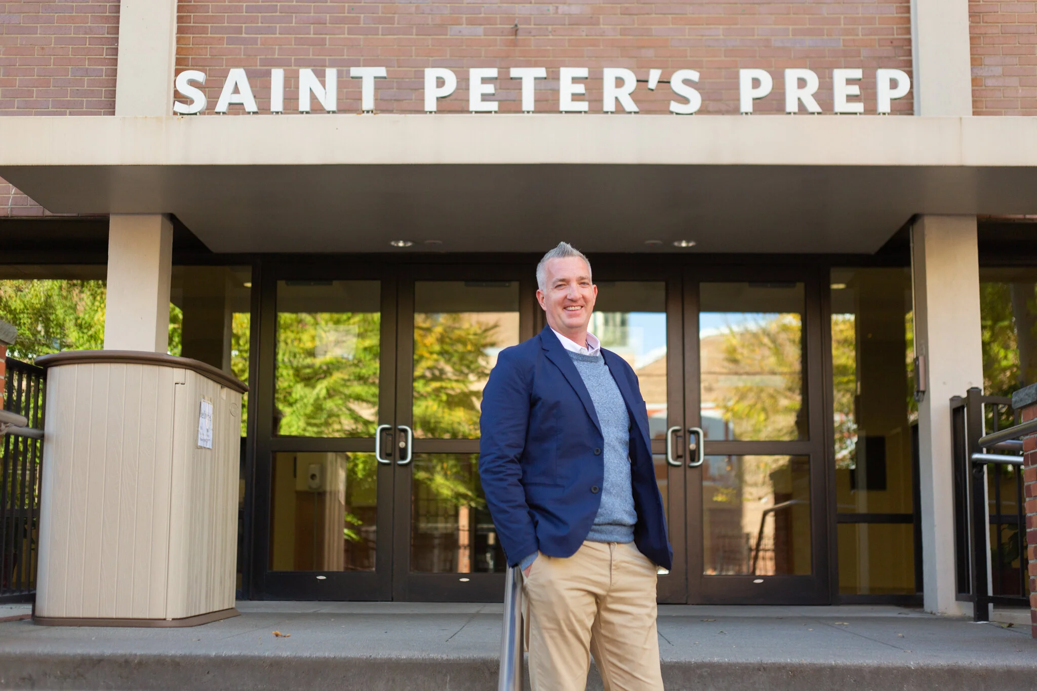Executive Coach Pat McKeon stands in front of a school in Jersey City in this NJ brand photography session