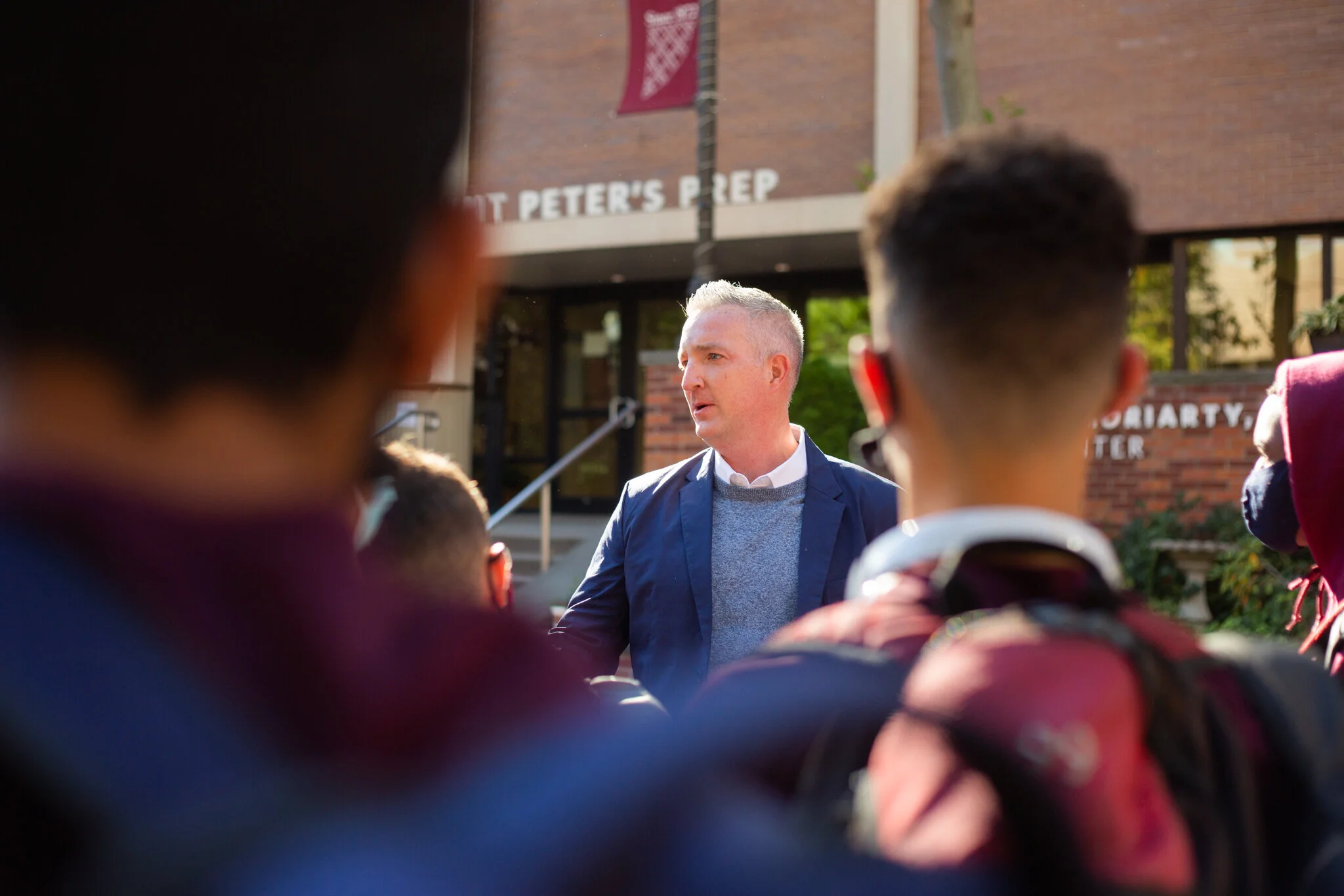 A man speaks with students in front of a school in Jersey City in this NJ branding photography session