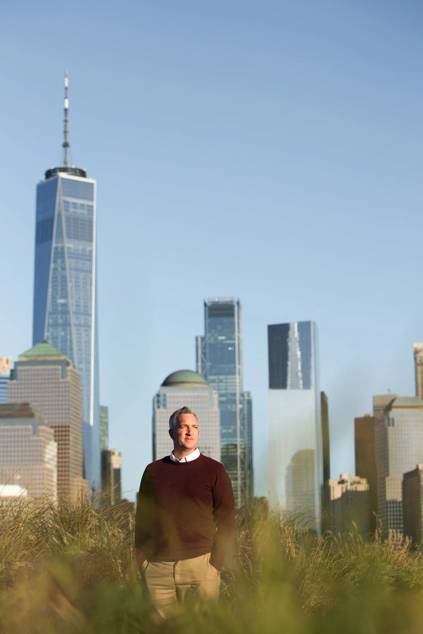 Editorial-style portrait of man with city skyline behind him at Liberty State Park during NJ brand shoot