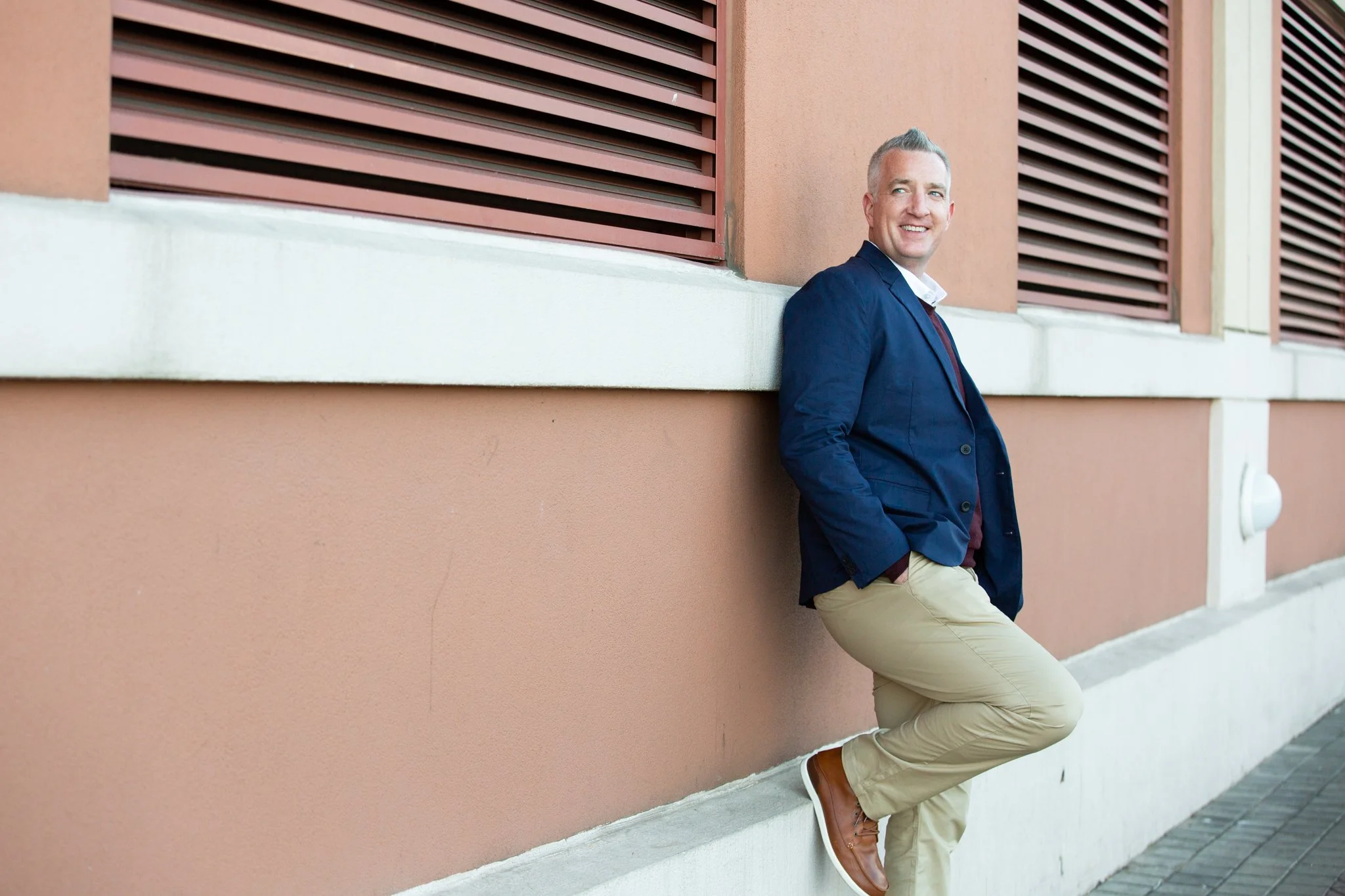 Modern brand photo of man leaning against terra-cotta wall at Liberty State Park, Jersey City