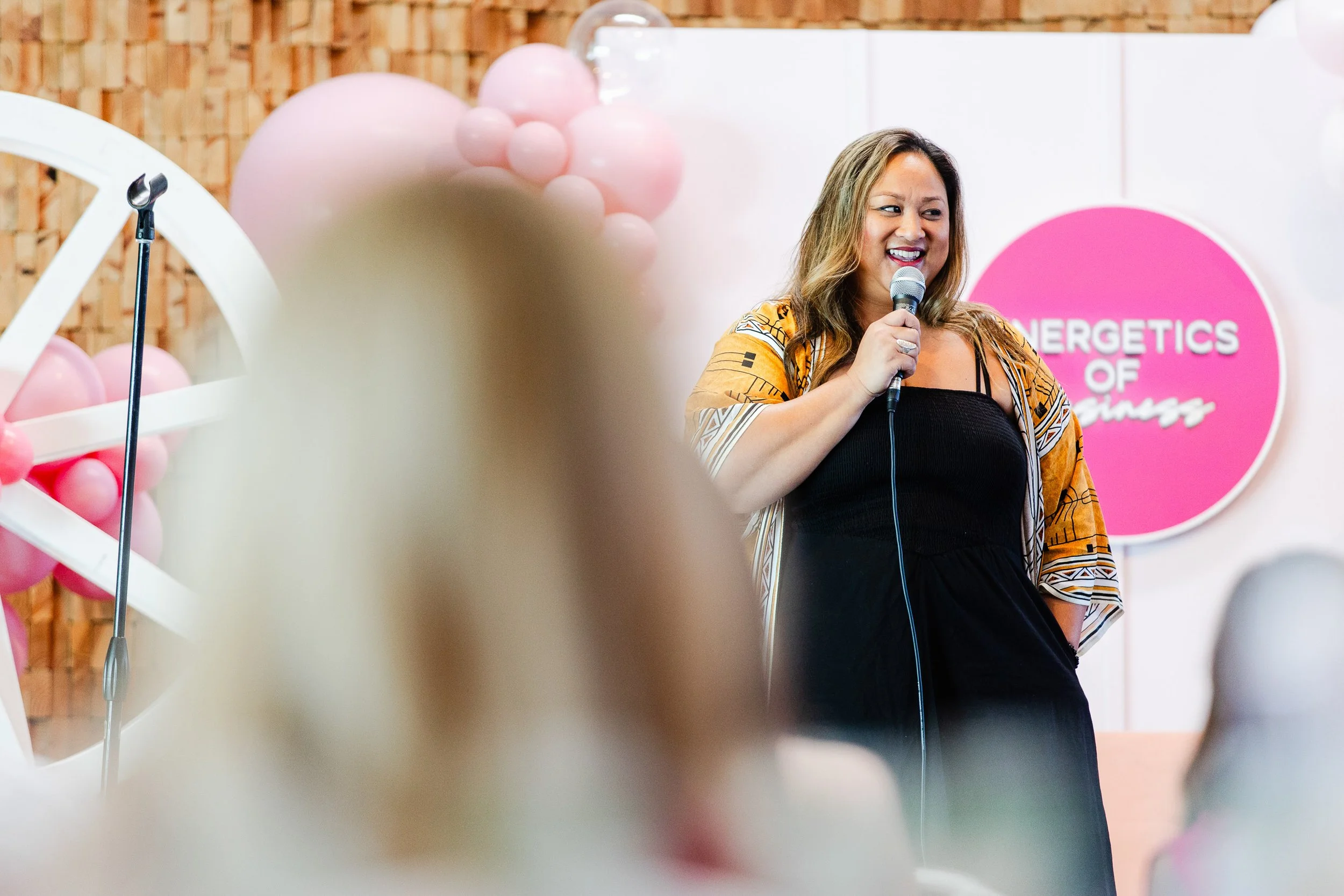 Horizontal closeup of female keynote speaker presenting at Energetics of Business event