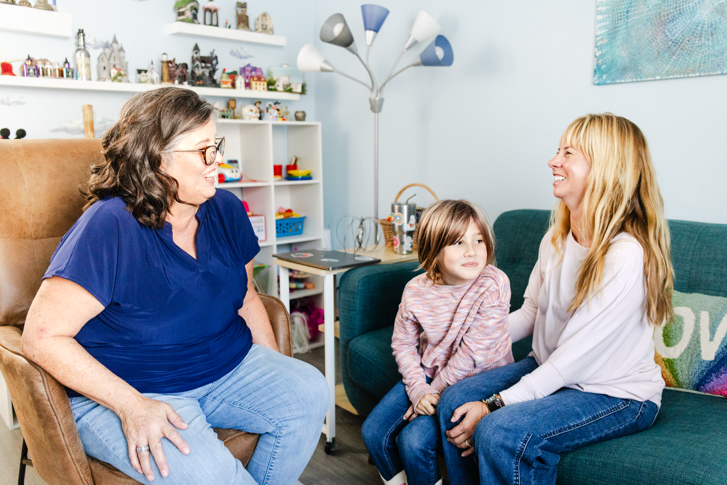 An LMFT talks with a mom and daughter client during a brand photography session for her therapy business.
