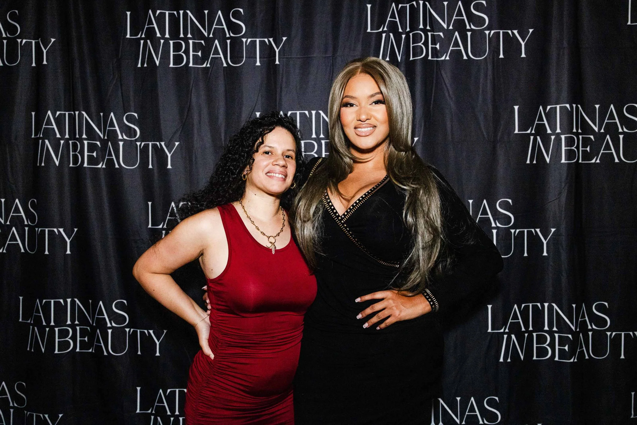 Two women pose on the Latinas in Beauty step-and-repeat at a red carpet event, captured as part of Los Angeles event photography coverage.