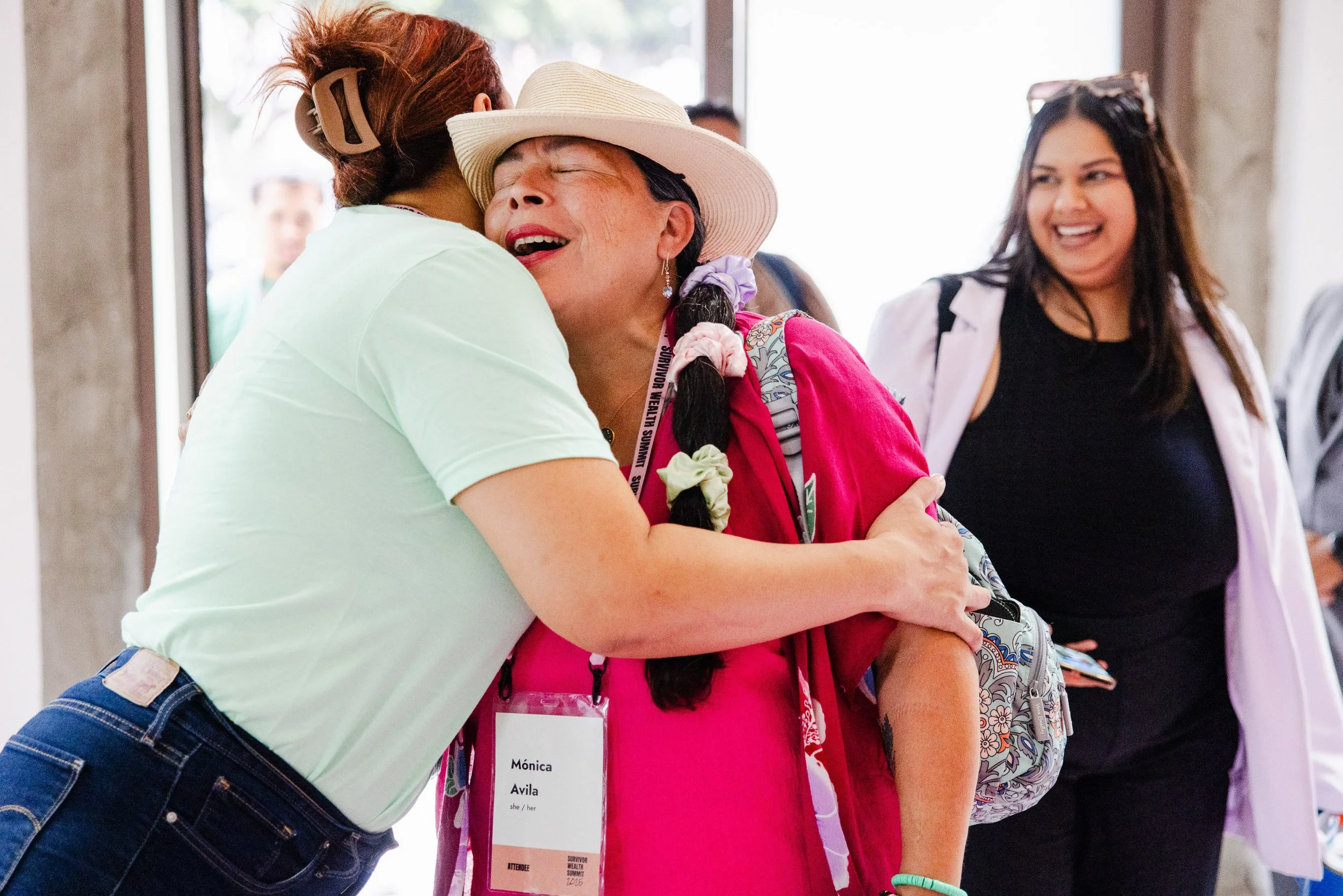 Two people hug at the Survivor Wealth Summit nonprofit event in DTLA