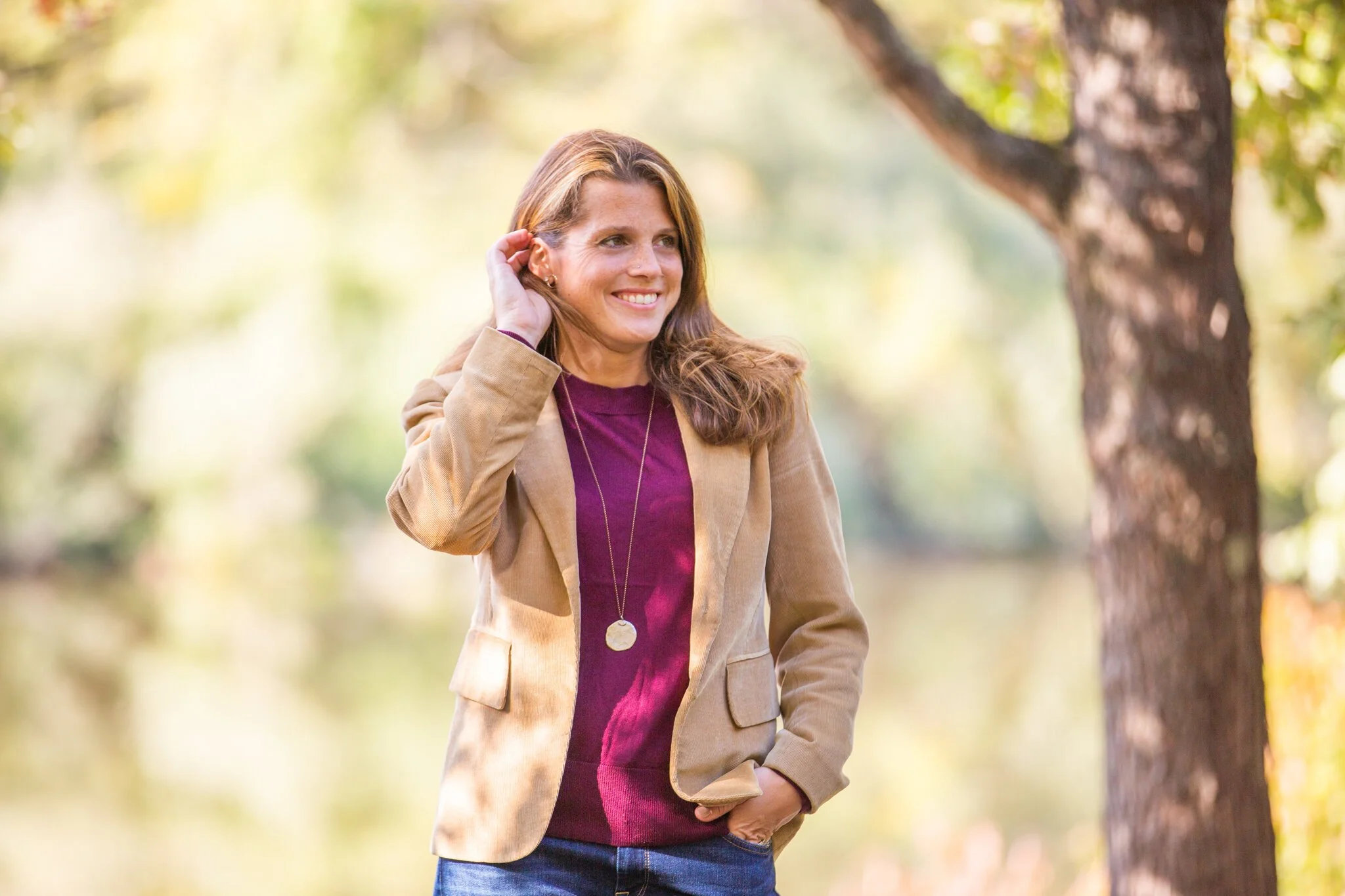 Outdoor brand portrait of a woman in fall styling holding coffee and smiling during a NJ brand photoshoot