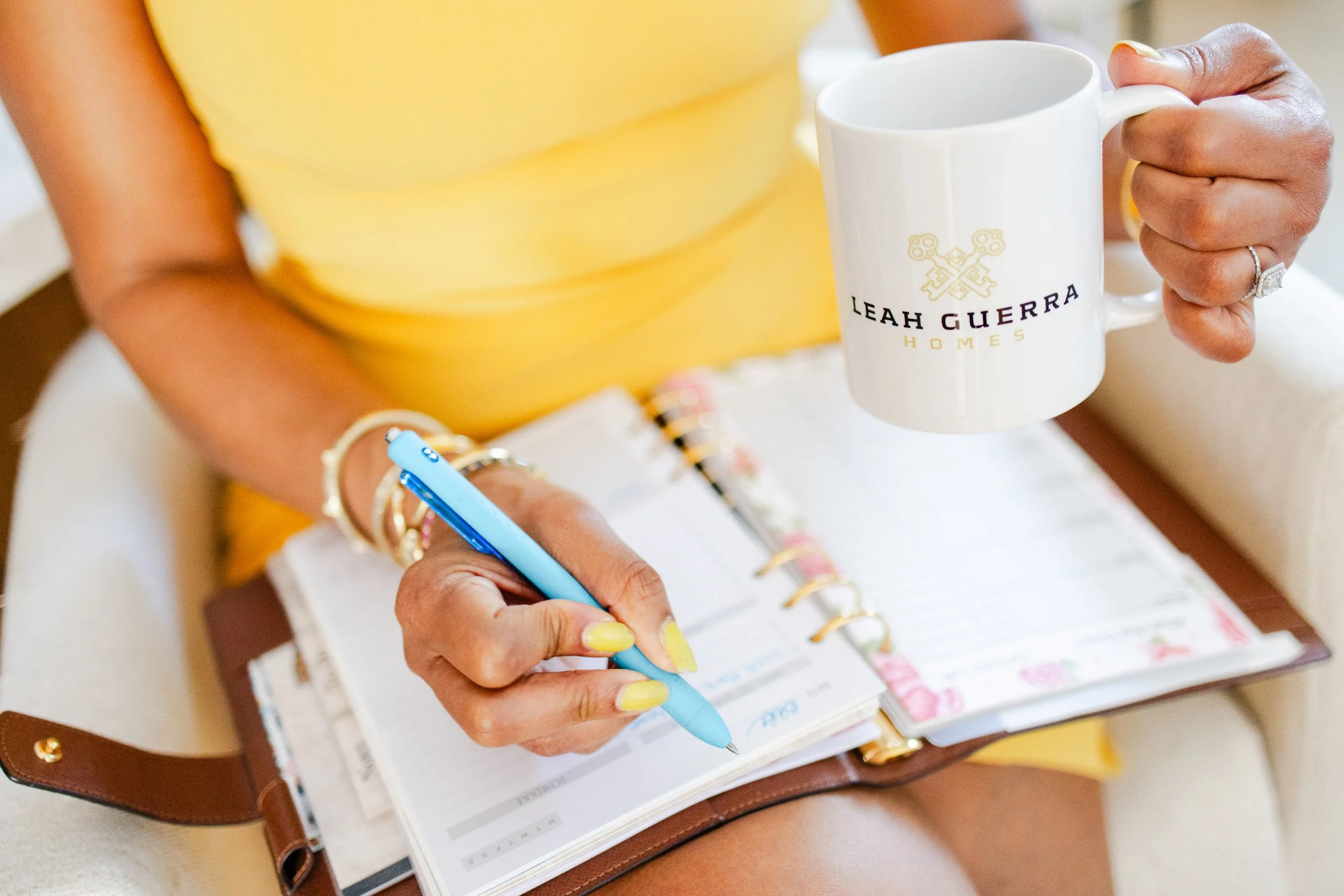 Brand photography session in Los Angeles capturing realtor writing in her planner, with her branded mug showing