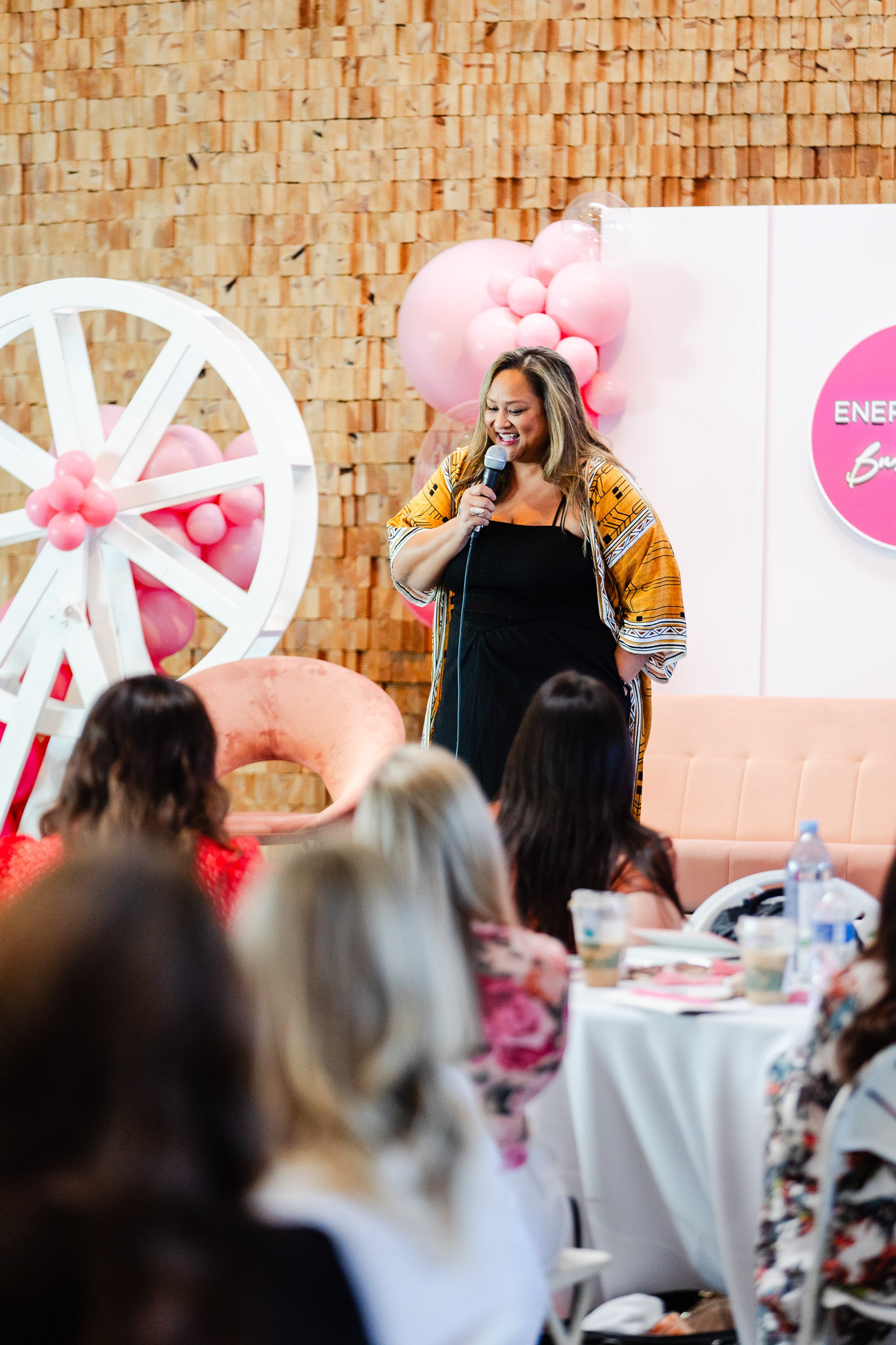 Vertical medium length photo of female keynote speaker presenting at Energetics of Business event