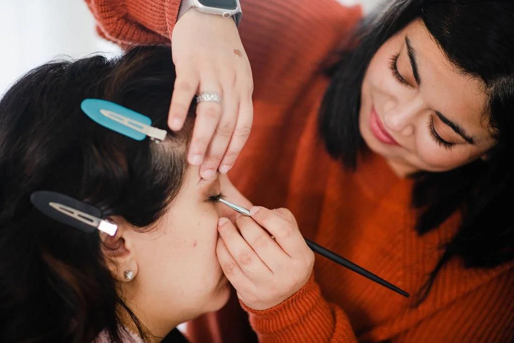 Client receiving professional makeup touch-up before her NJ brand photography session