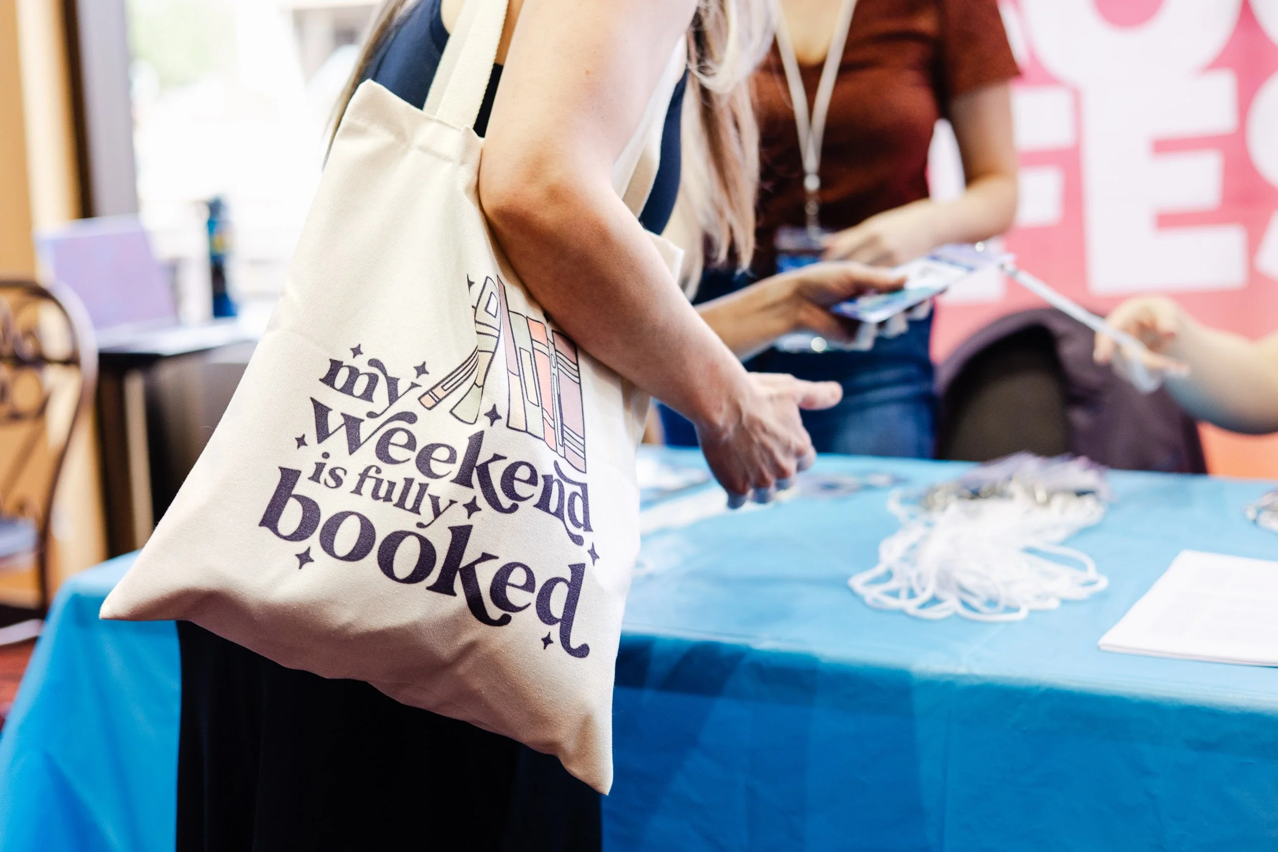Palm Springs Book Fest attendee carrying books and festival tote bags.