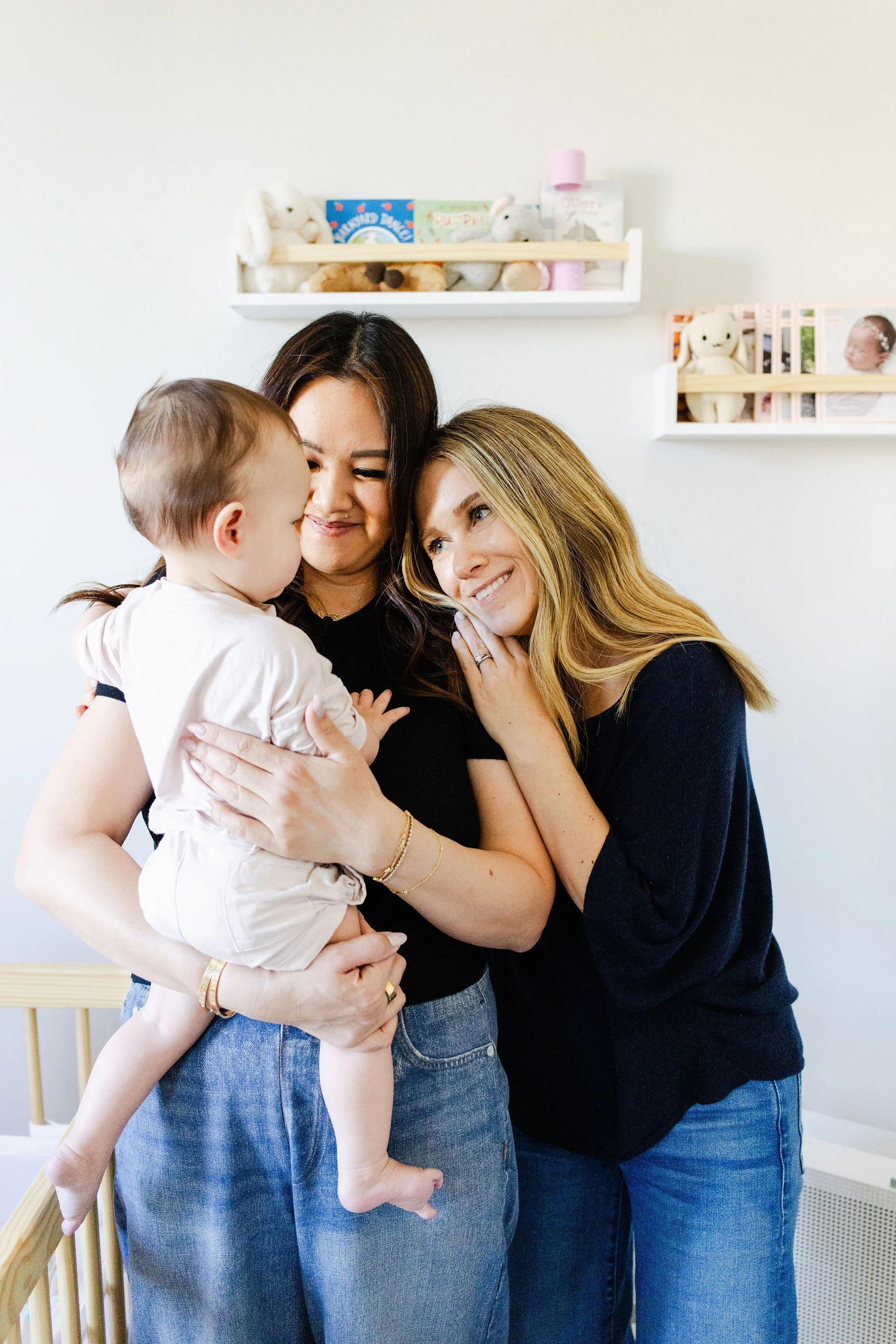 Pediatric sleep consultant shares a sweet moment with a mother and baby in a nursery, captured for Los Angeles brand photos for parenting coaches.