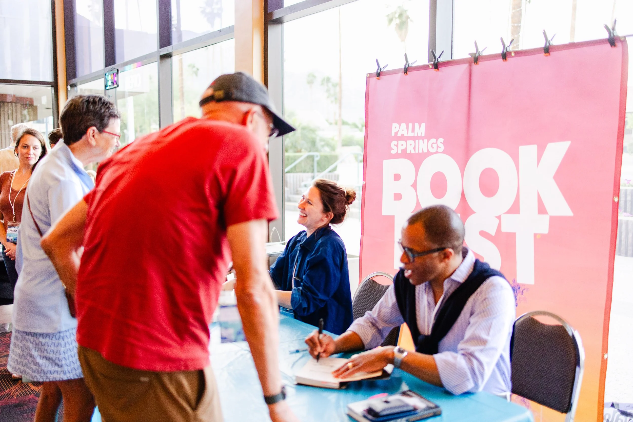 Author signing books for attendees during Palm Springs Book Fest.