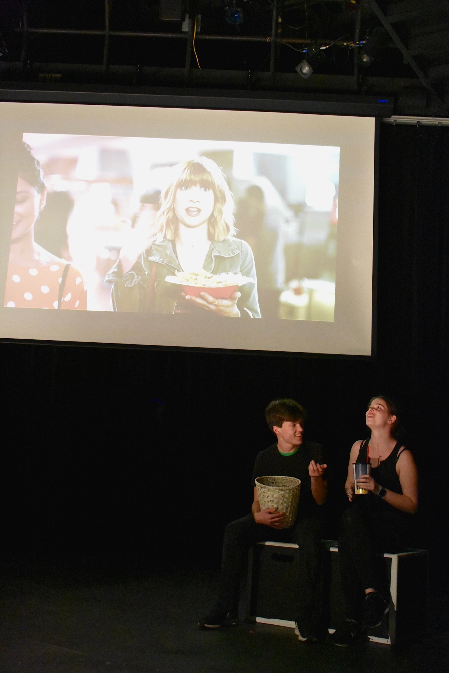 Deciding in person activity is better, the friend travels to the theater, enjoying mocking the pre-show trailers.