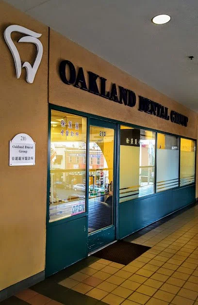 Exterior view of Oakland Dental Group office with its logo, sign, and glass door and windows.