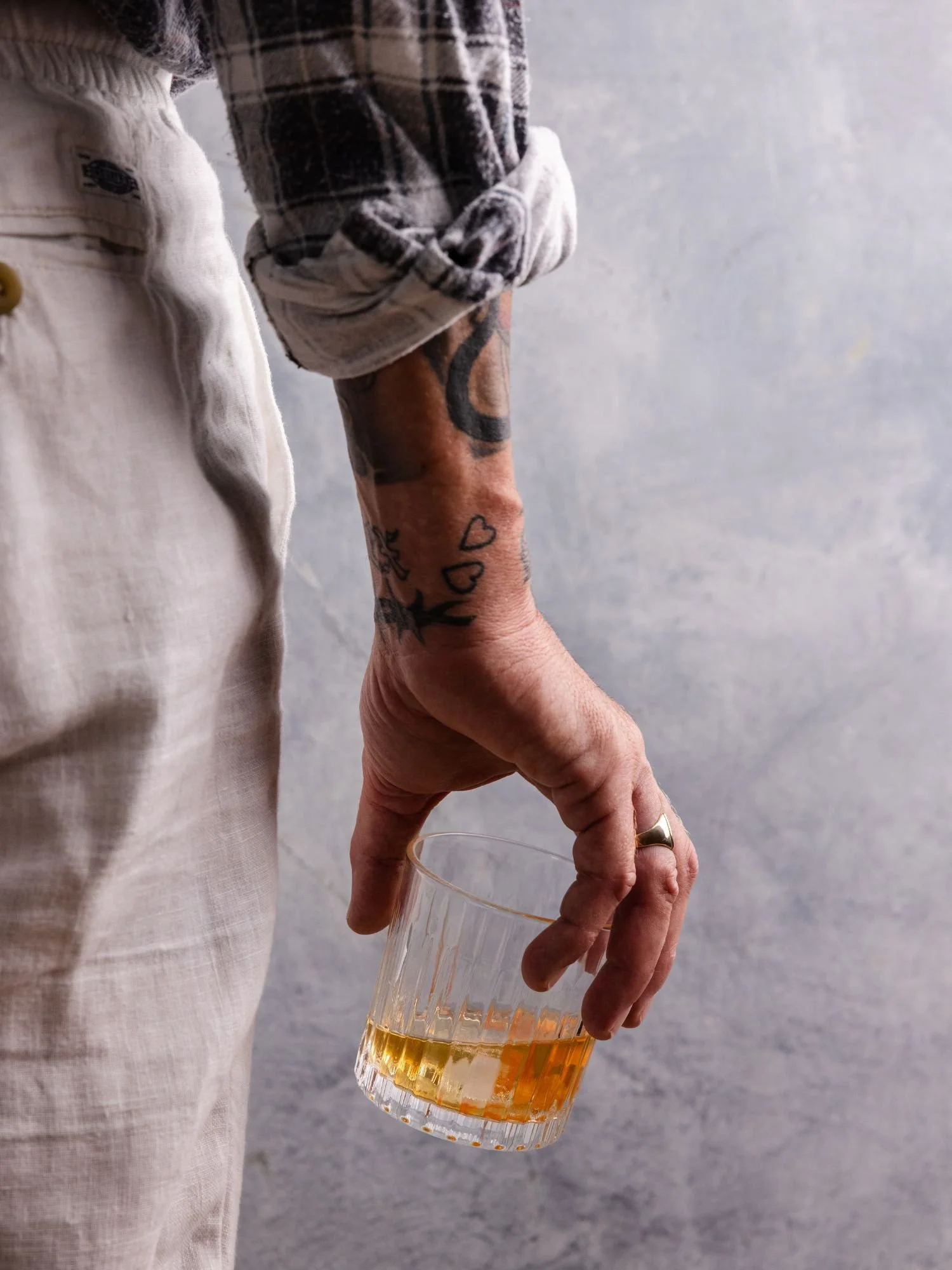 Arm holding a glass of Cape Grim tallow-washed whisky