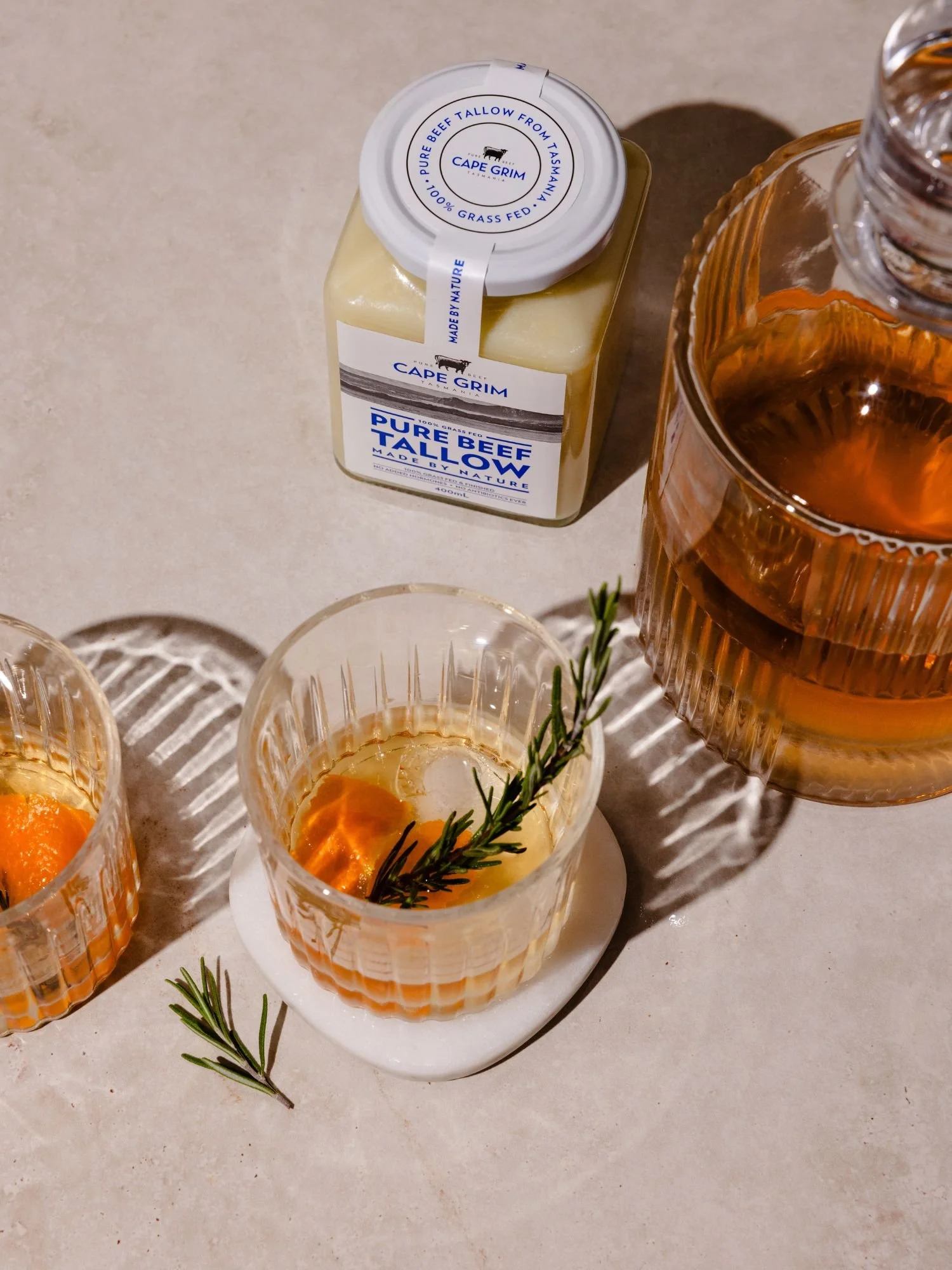 Cape Grim tallow washed whisky in glass with whisky bottle and tallow jar