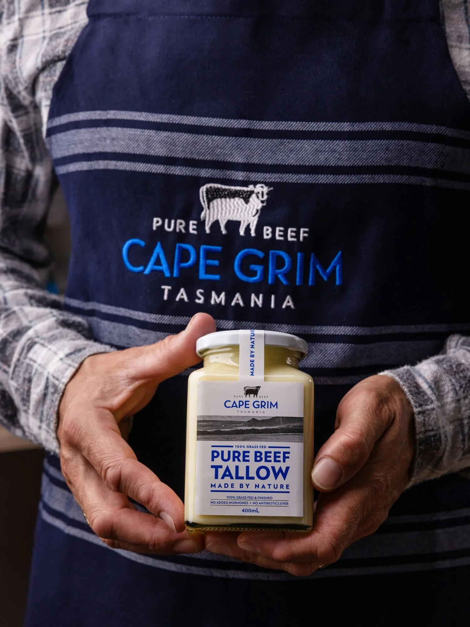 Hands holding Cape Grim tallow jar