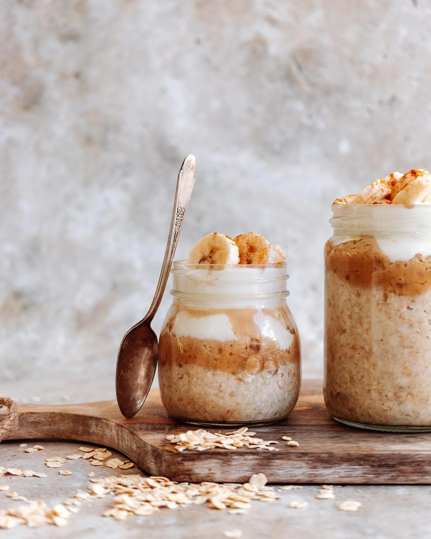 Banoffee overnight oats in a glass jar topped with banana and coconut yoghurt