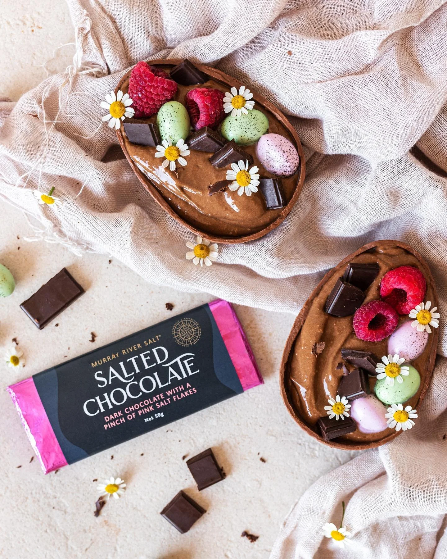 Salted chocolate mousse served in halved chocolate eggs with raspberries