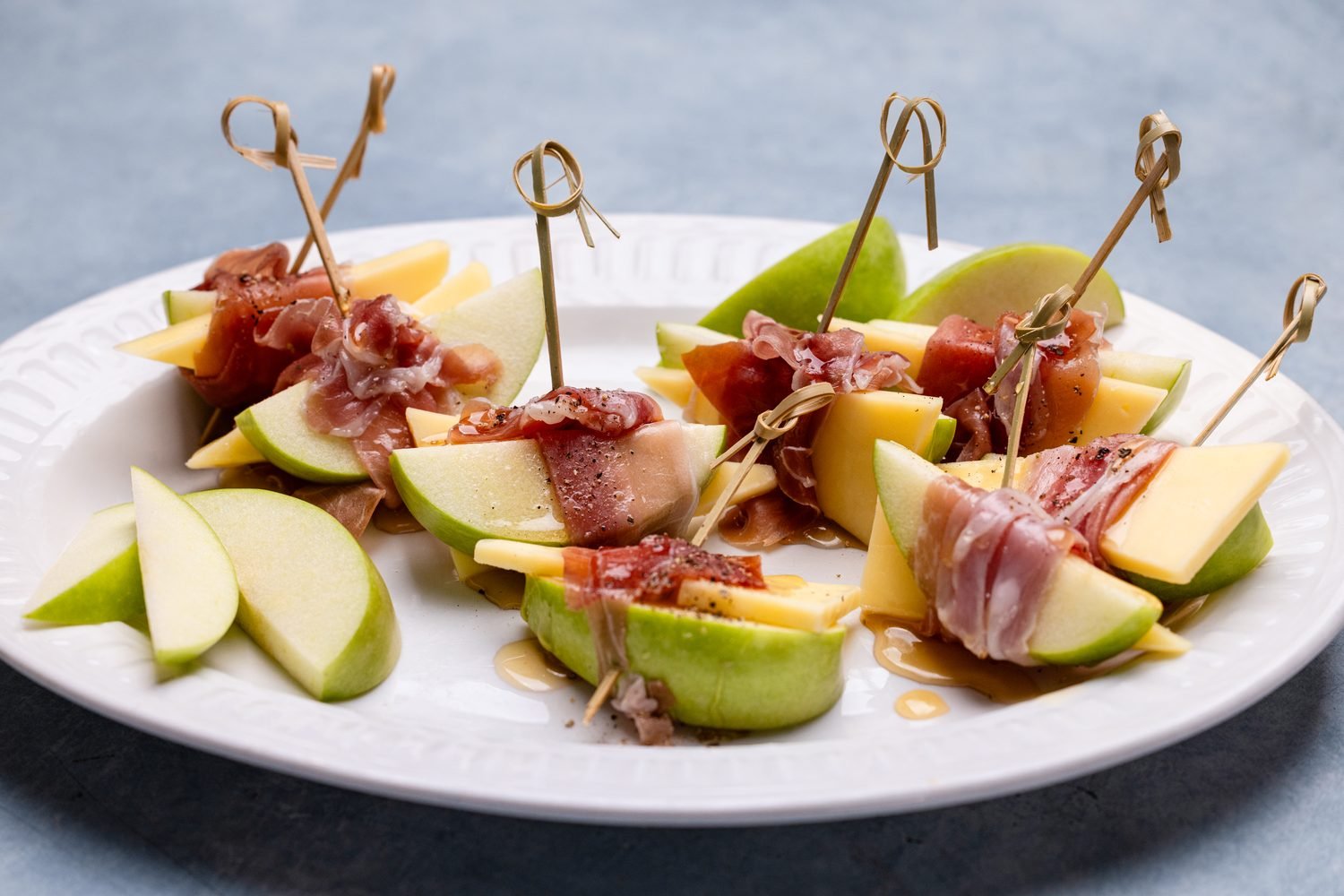 Apple, prosciutto, cheese and honey canapés on skewers