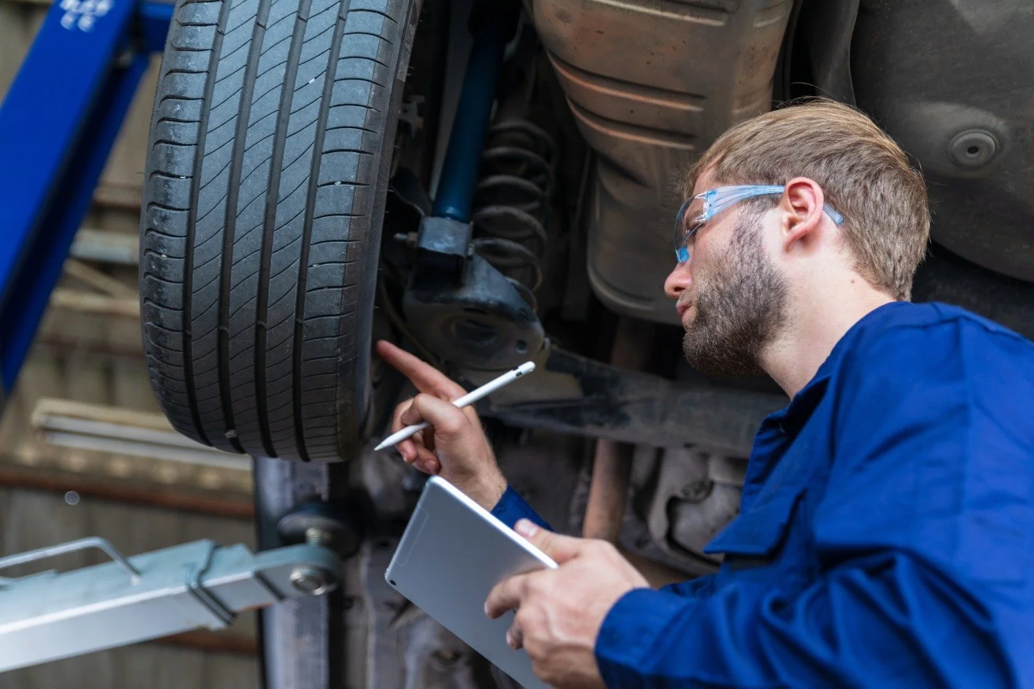 mechanic inspecting car tyre