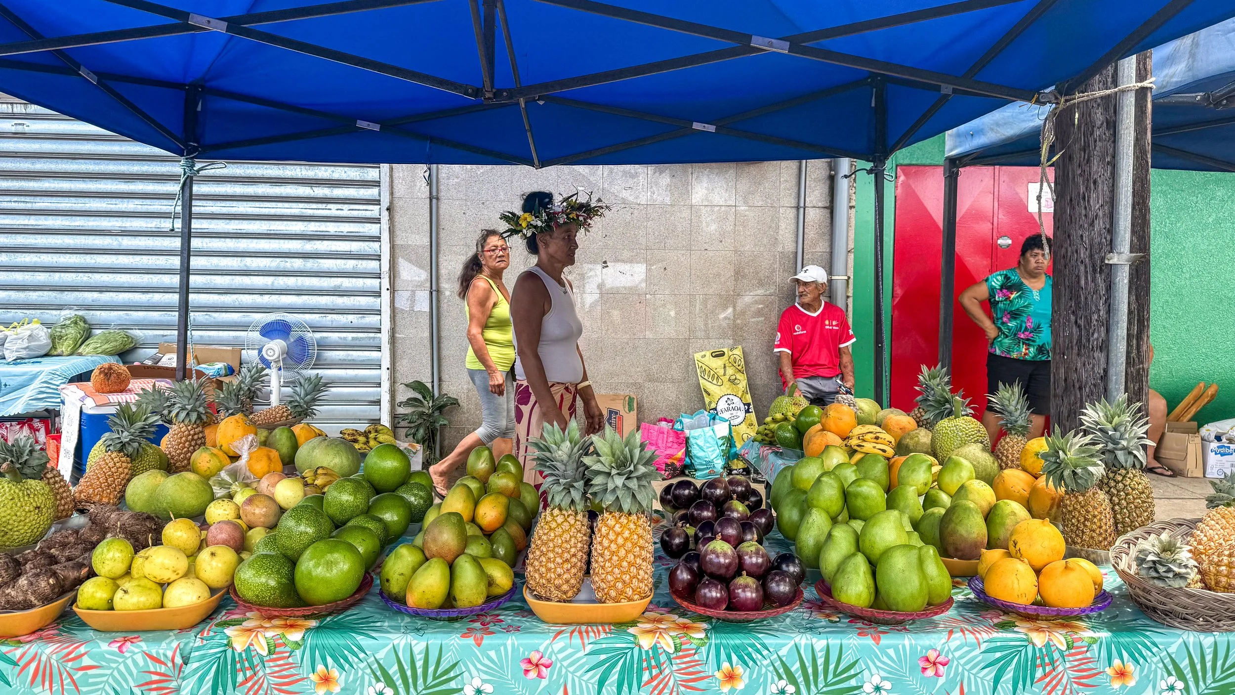 Tropical fruit stand with mangos, pineapples, passion fruits and avocados street in Huahine, French Polynesia