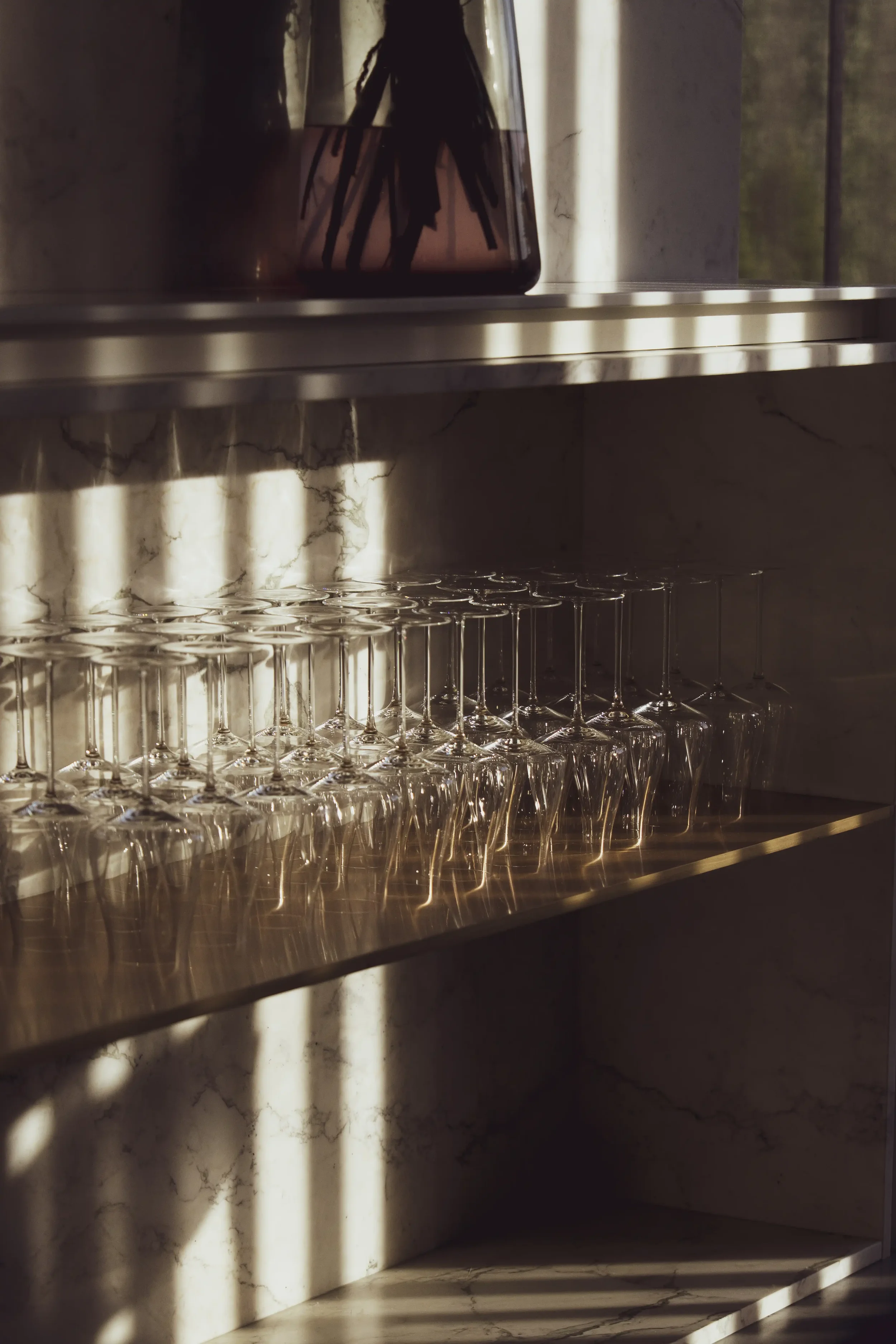 Wijn- en waterglazen in warm avondlicht in het stijlvolle interieur van Restaurant Les Deux.