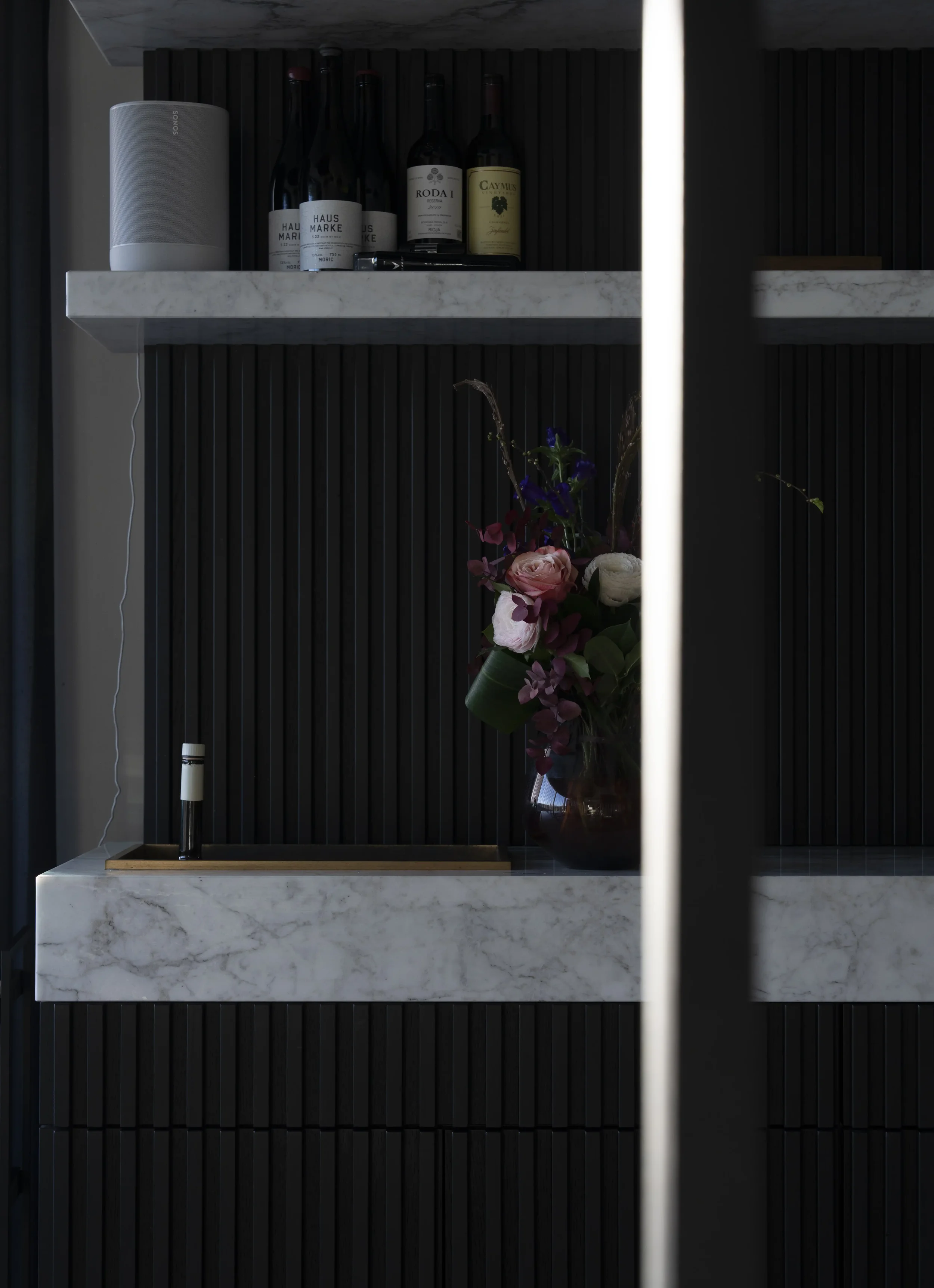 Marmeren wandrekken met bloemen en zorgvuldig geselecteerde wijnen in Restaurant Les Deux.