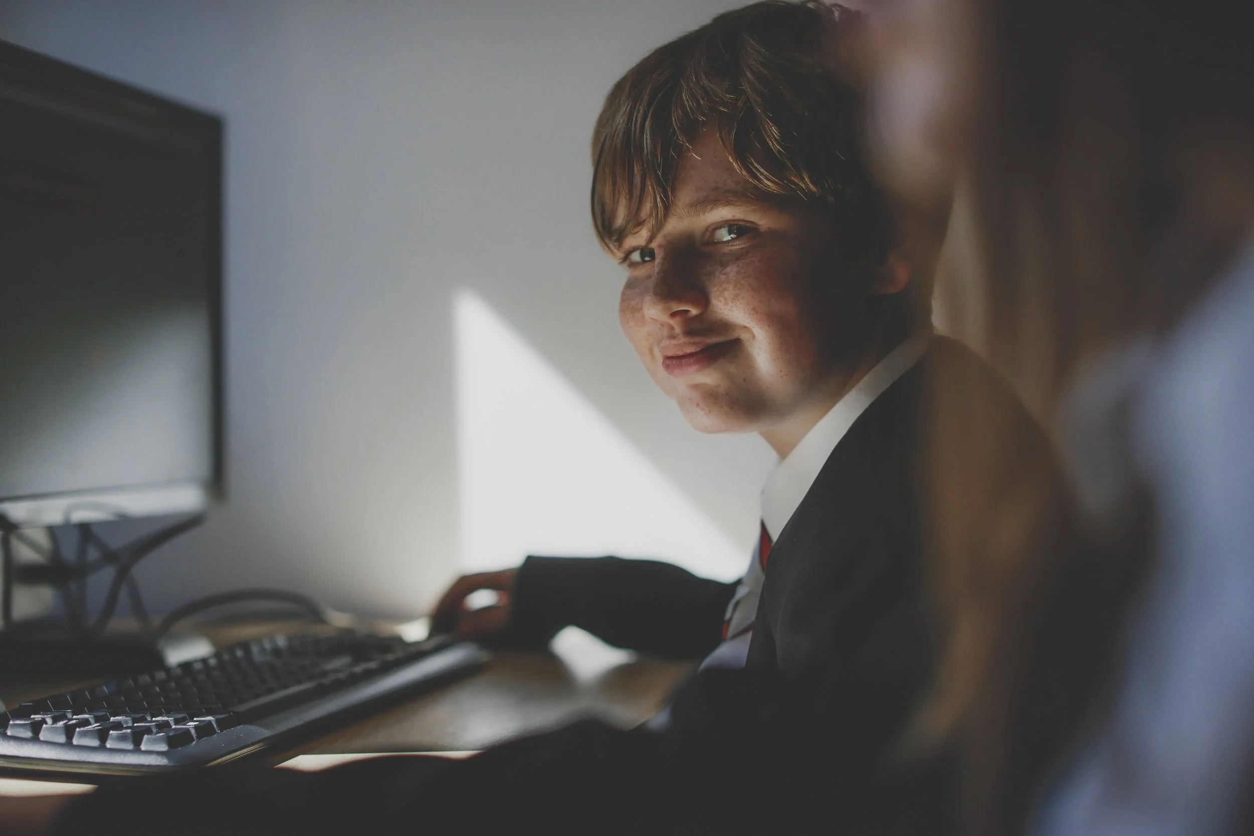 Secondary school pupil smiling in class, school photography by Brett Harkness, Fylde Coast