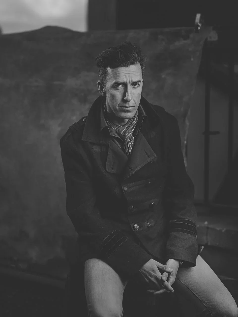 Black and white portrait of a man in a heavy coat and scarf by Brett Harkness