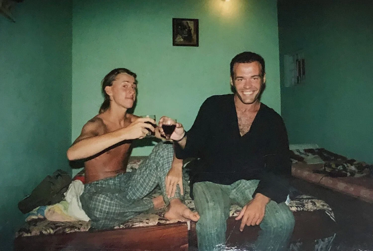Brett and Mike raising a toast in a guest house room in India, 1995