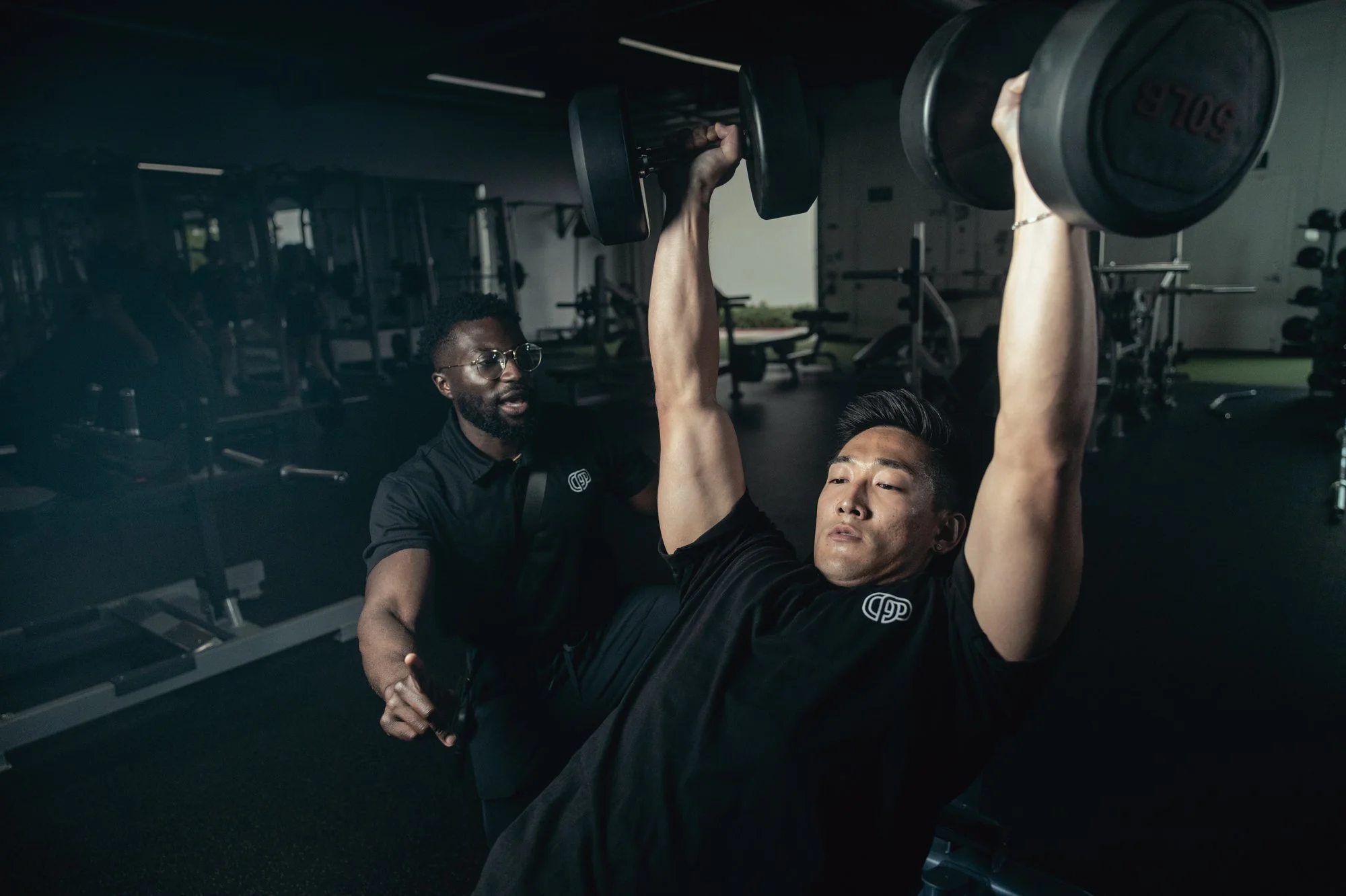 Experienced personal trainer providing support to a client during a workout session in Orange County.