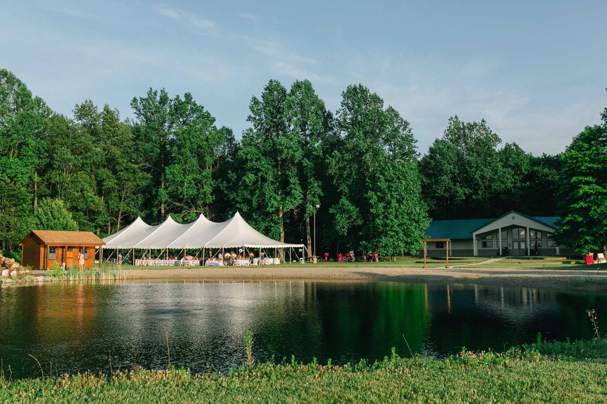 The tent, the pond, and the event building at Wildflower Estate