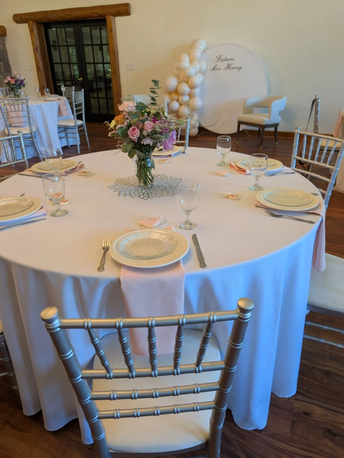 Round table with full place settings, goblets and florals at a Wildflower Estate bridal shower