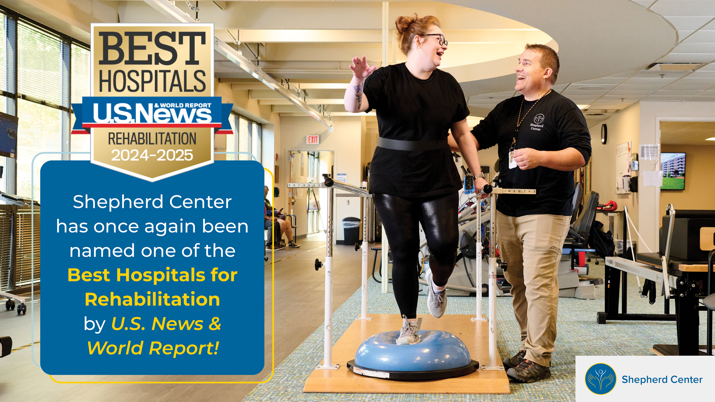 A woman in black exercise clothes and a man in beige pants and black shirt are smiling and celebrating as she uses a balance training device with assistance from the man in a rehabilitation center for Shepherd Center