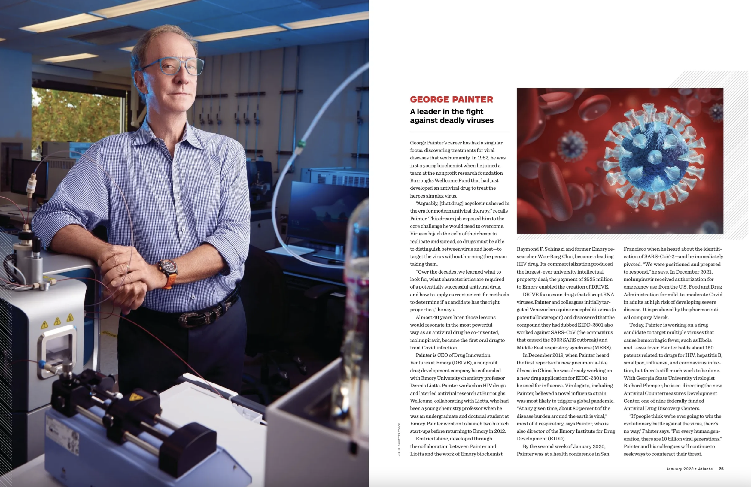 A scientist standing in a laboratory next to scientific equipment, with a computer monitor and molecular models on the desk.