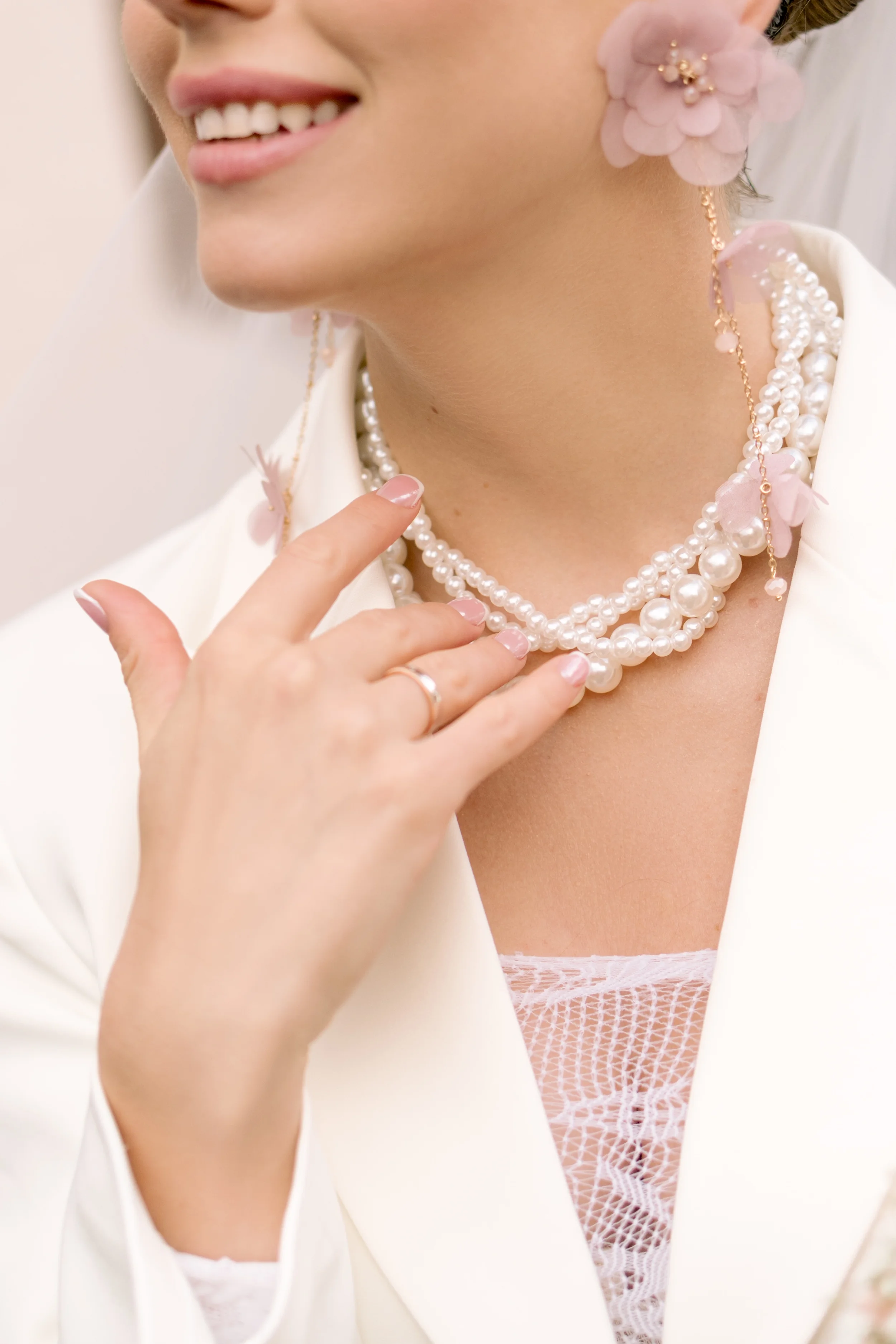Detailaufnahme einer Braut mit Perlenkette, floralen Ohrringen und modernem Hochzeitslook während einer standesamtlichen Hochzeit