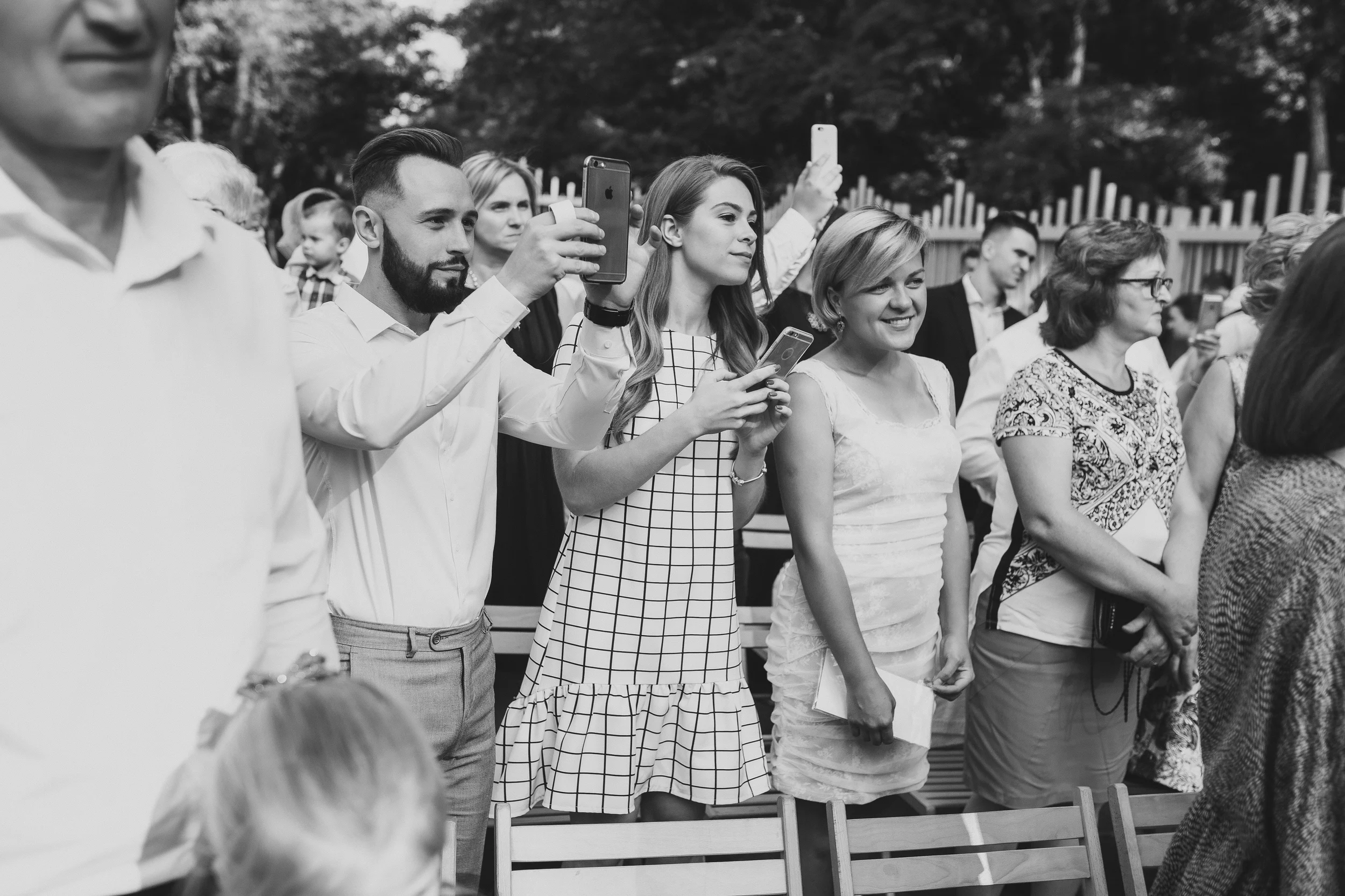 Menschen bei einer Veranstaltung, die Fotos machen und zuschauen.