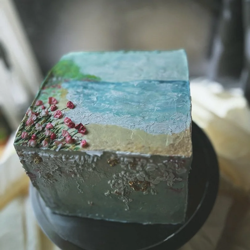 Square buttercream cake with coastal landscape painting and textured palette-knife finish, Grand Rapids, MI