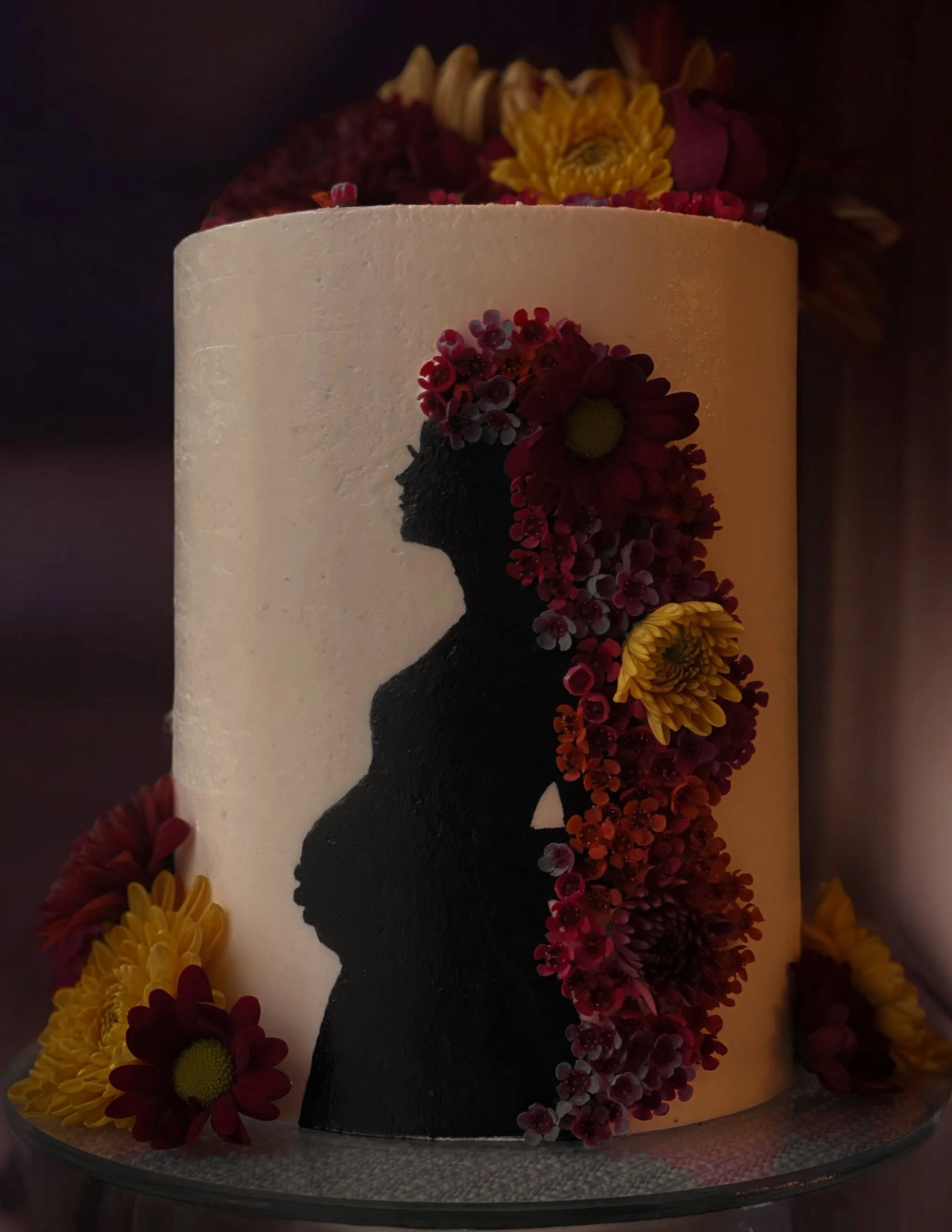 Baby shower cake with hand-painted pregnant silhouette and colorful floral hair detail on buttercream, West Michigan