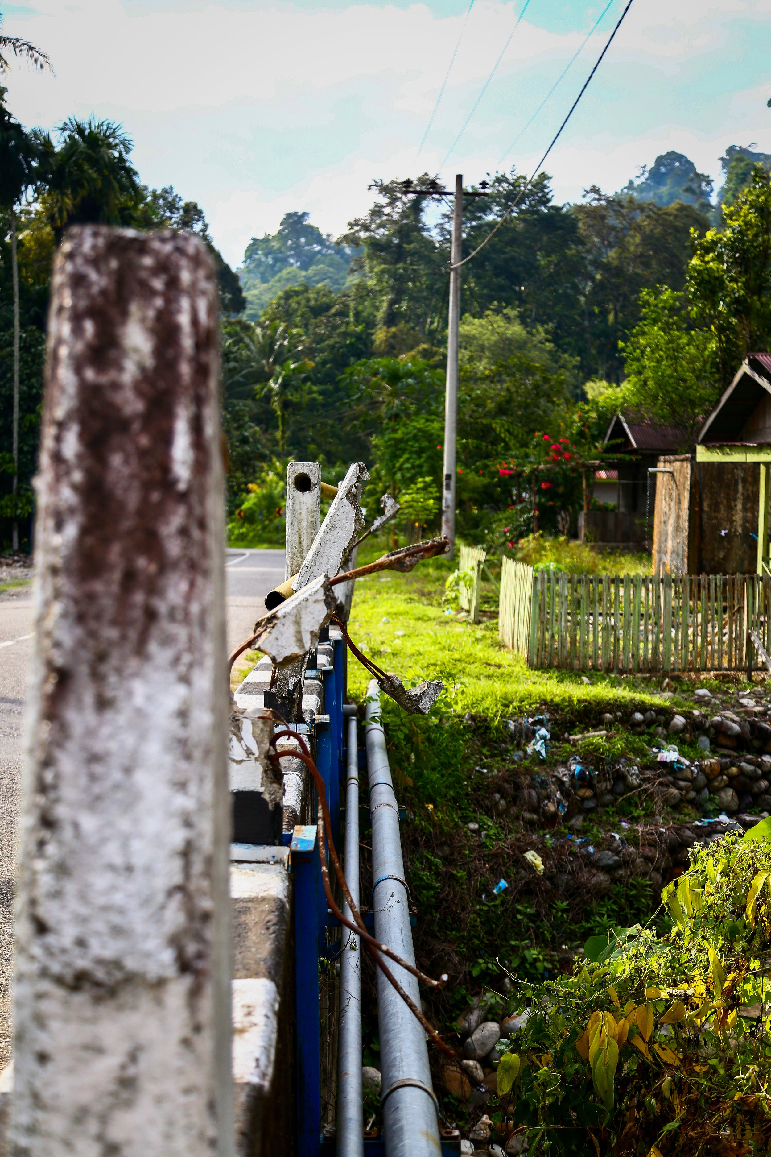 A slanted guardrail, wrecked from floods and accidents in Ketambe.
