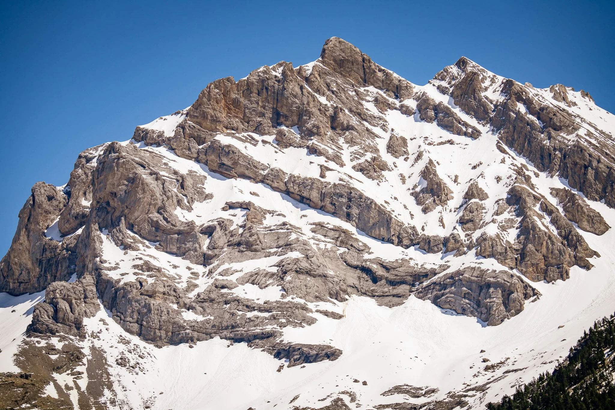 Snow-covered mountain peaks under a clear blue sky.