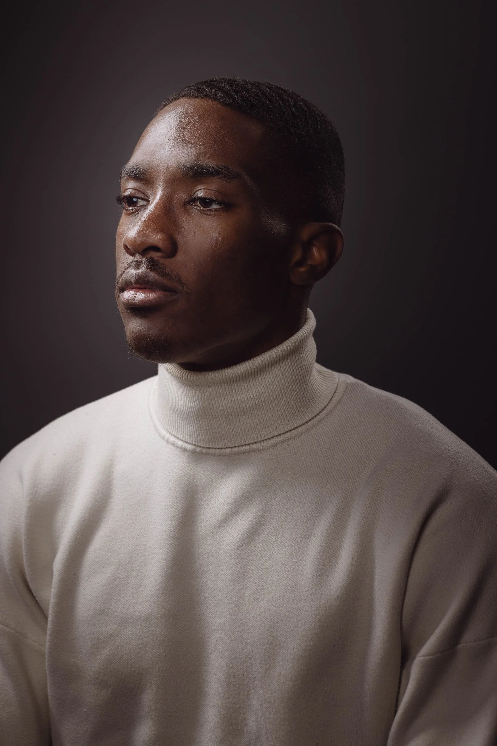 Portrait of a young man wearing a white turtleneck shirt