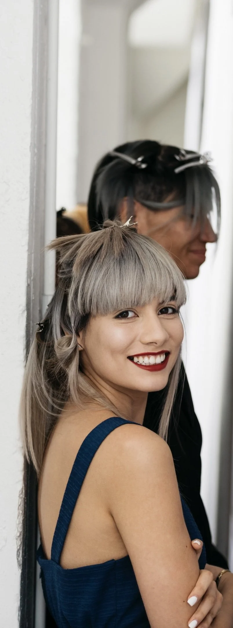 Smiling ash blonde long-hair model with a fringe behind the scenes getting ready to go on stage.