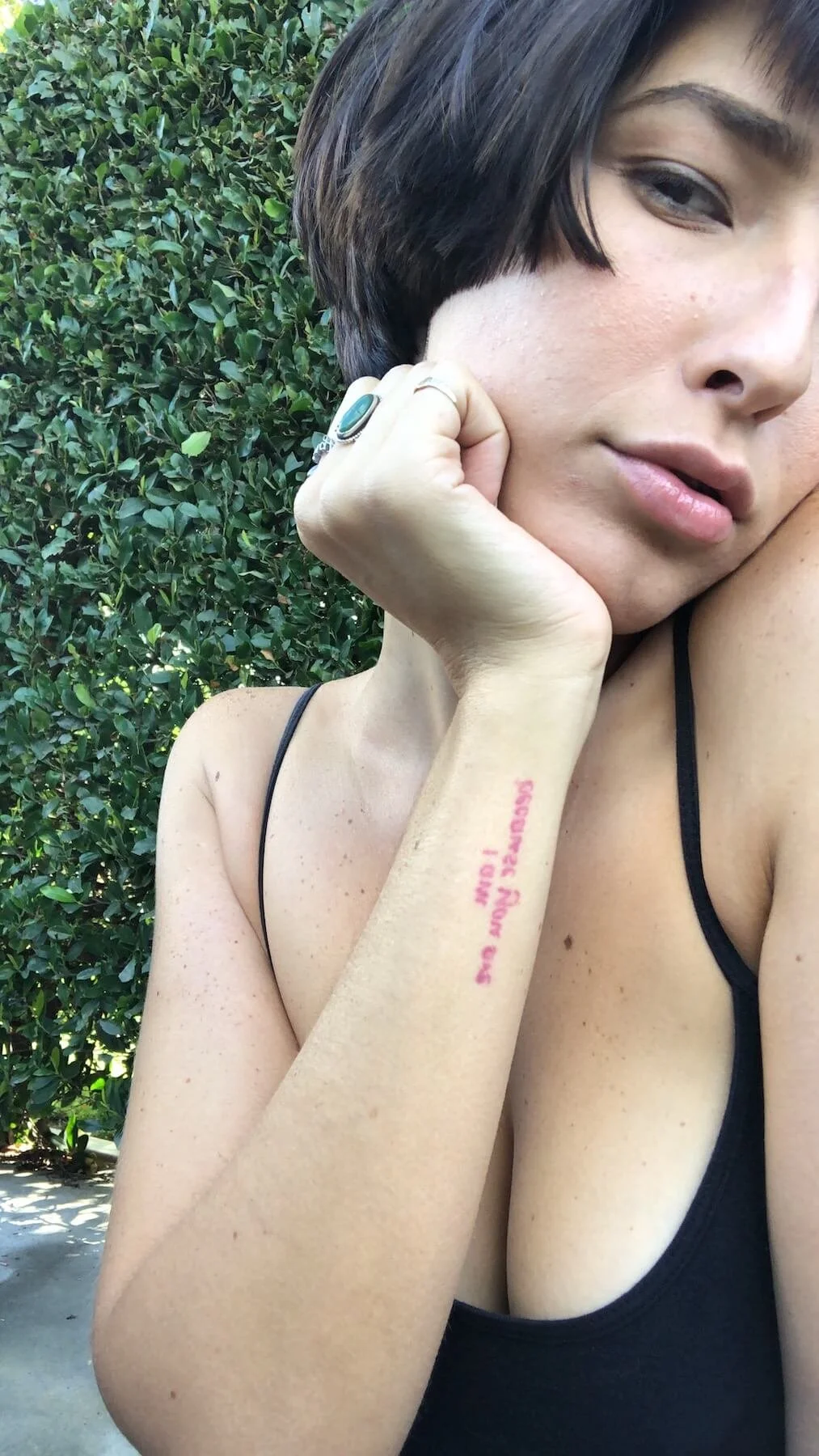 Sexy brunette with a cute french bob haircut, having her hand on her cheek.