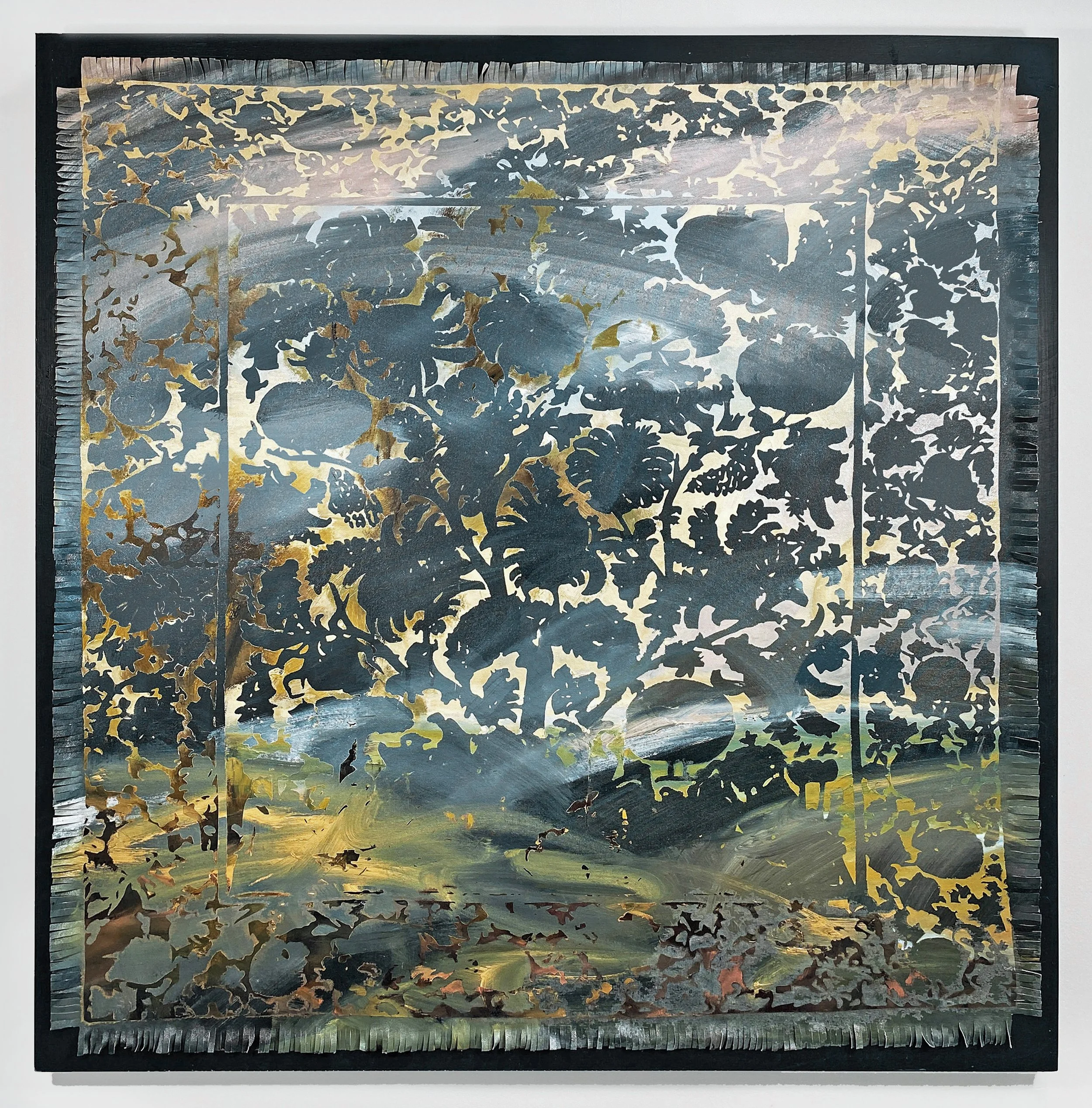 A decorative artwork featuring a cut-out floral design with gold accents, mounted on a backing with a landscape scene visible through the cut-outs.