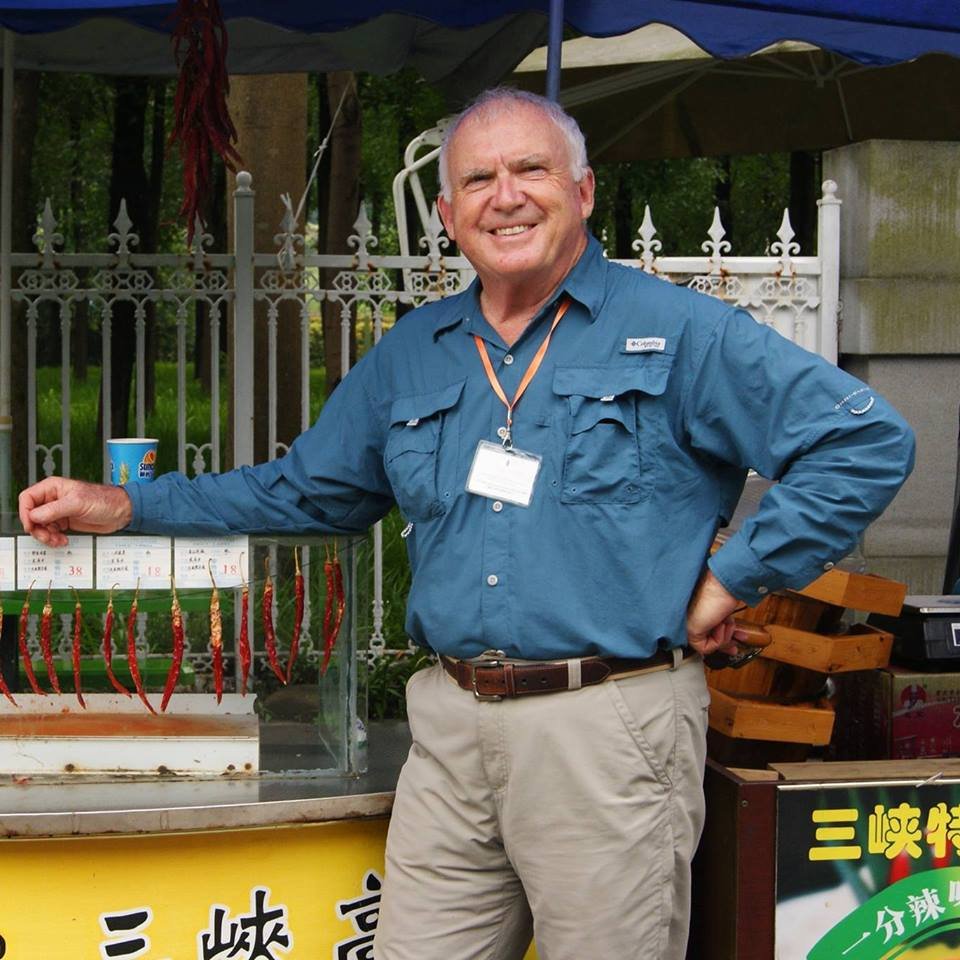 C.W. Armbrust stands in front of a food cart in China