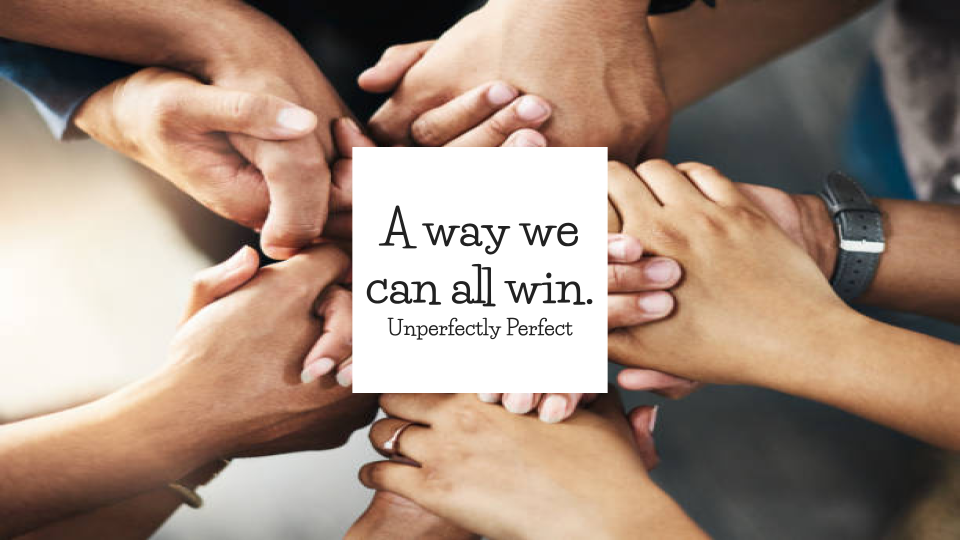 Multiple people placing their hands together in a teamwork gesture, with a quote in the center that reads 'A way we can all win.' - Unperfectly Perfect.